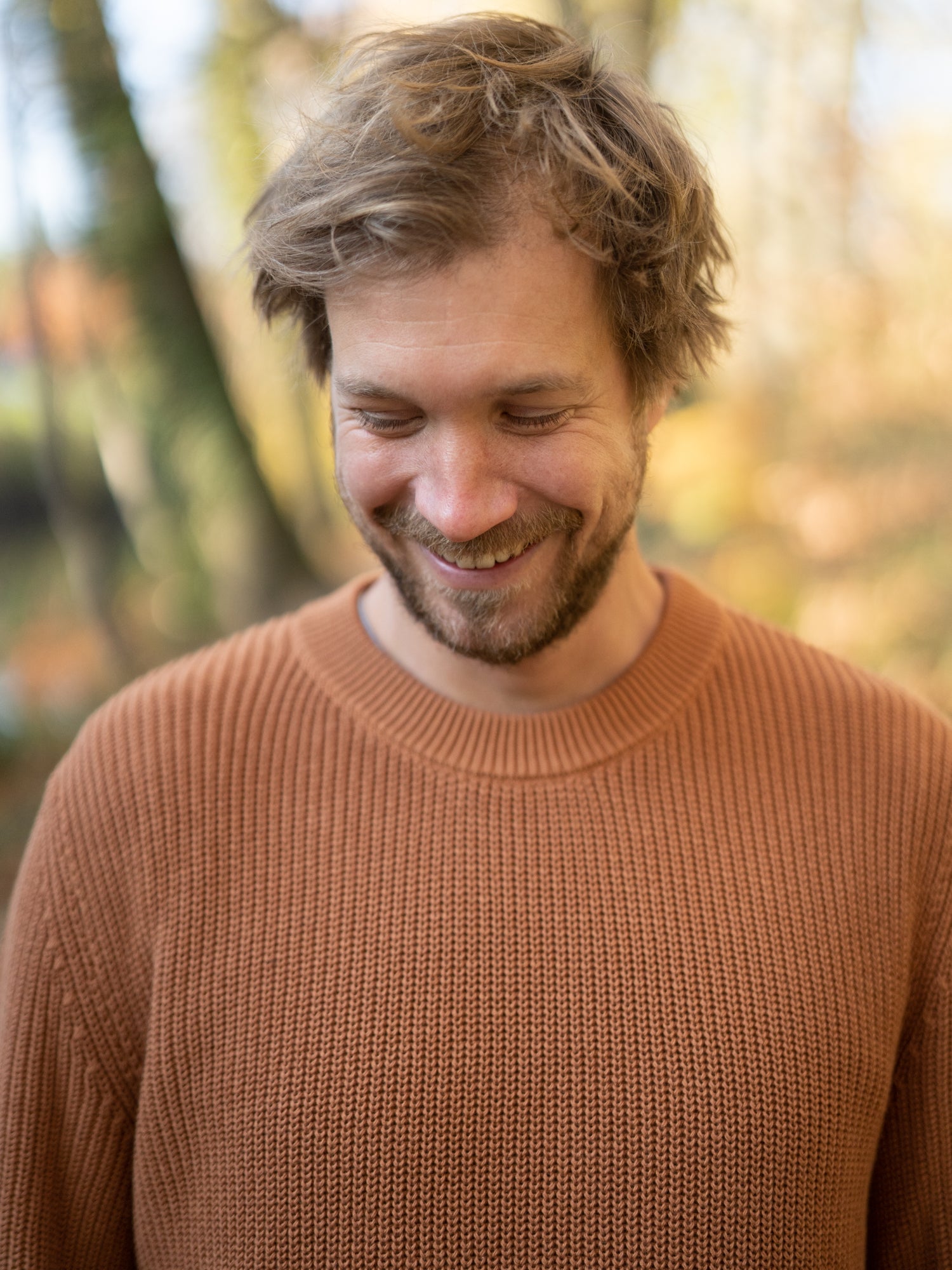 Nachhaltiger FUXBAU Fair Fashion 4Seasons Strickpullover aus GOTS zertifizierter Biobaumwolle Made in Italy. Getragen von einem jungen, blonden Mann im Herbst.