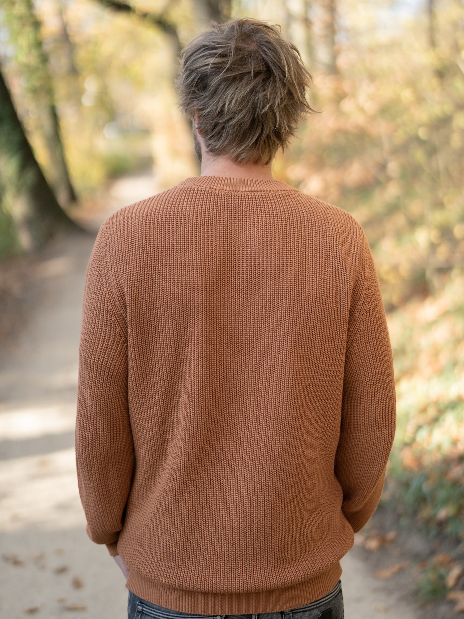 Nachhaltiger FUXBAU Fair Fashion 4Seasons Strickpullover aus GOTS zertifizierter Biobaumwolle Made in Italy. Getragen von einem jungen, blonden Mann im Herbst.