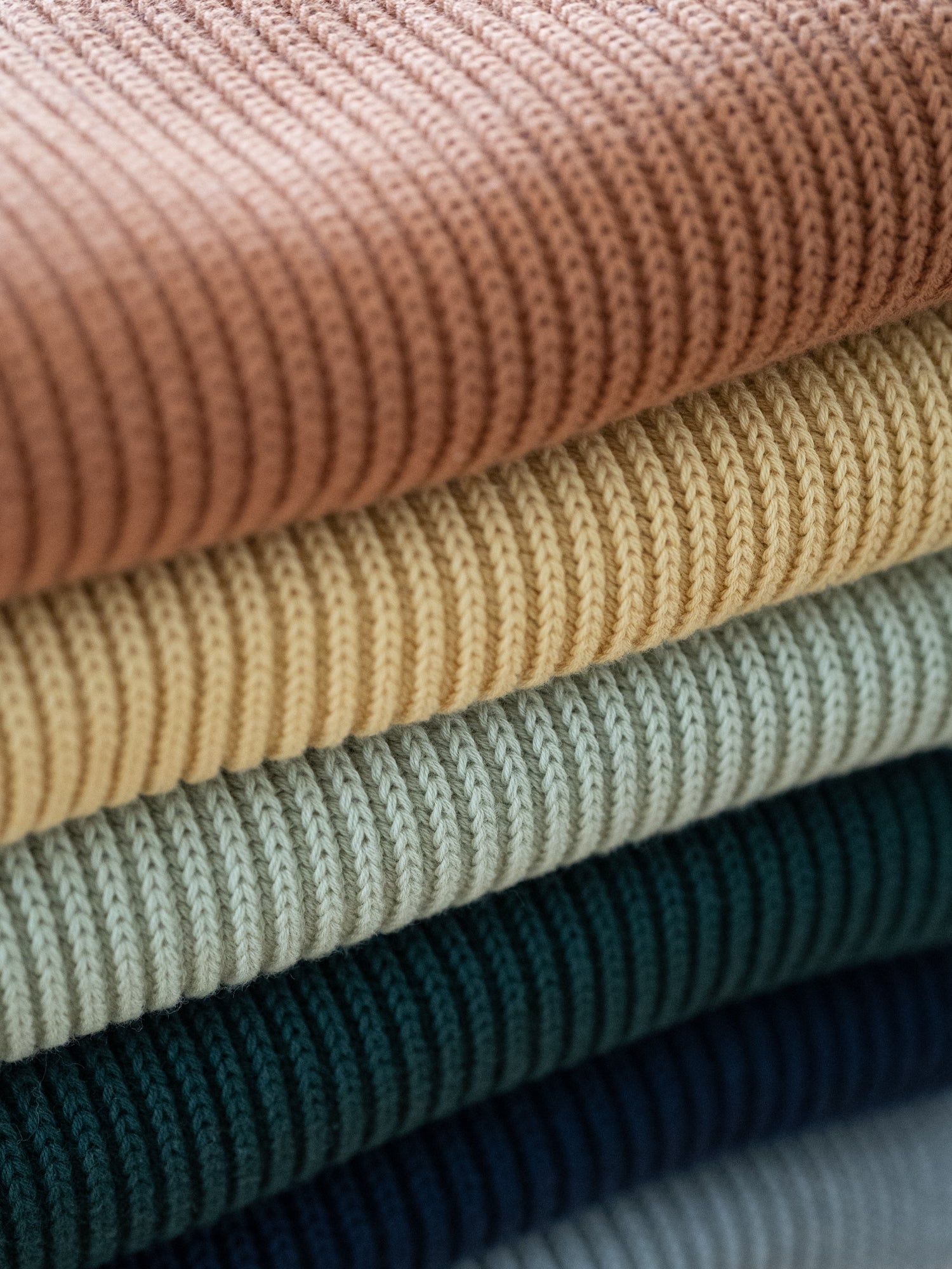 Stapel an nachhaltigen Fair Fashion Strickschals aus Biobaumwolle in verschiedenen Farben von FUXBAU.