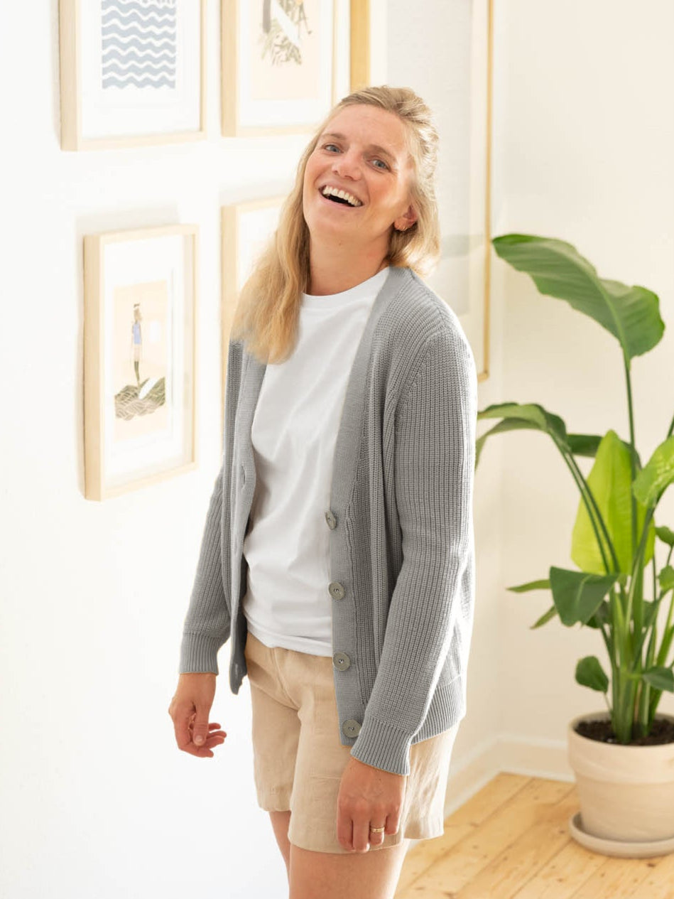 Isi trägt unsere FUXBAU 4Seasons Frauen Strickjacke in grau aus 100% GOTS zertifizierter Biobaumwolle