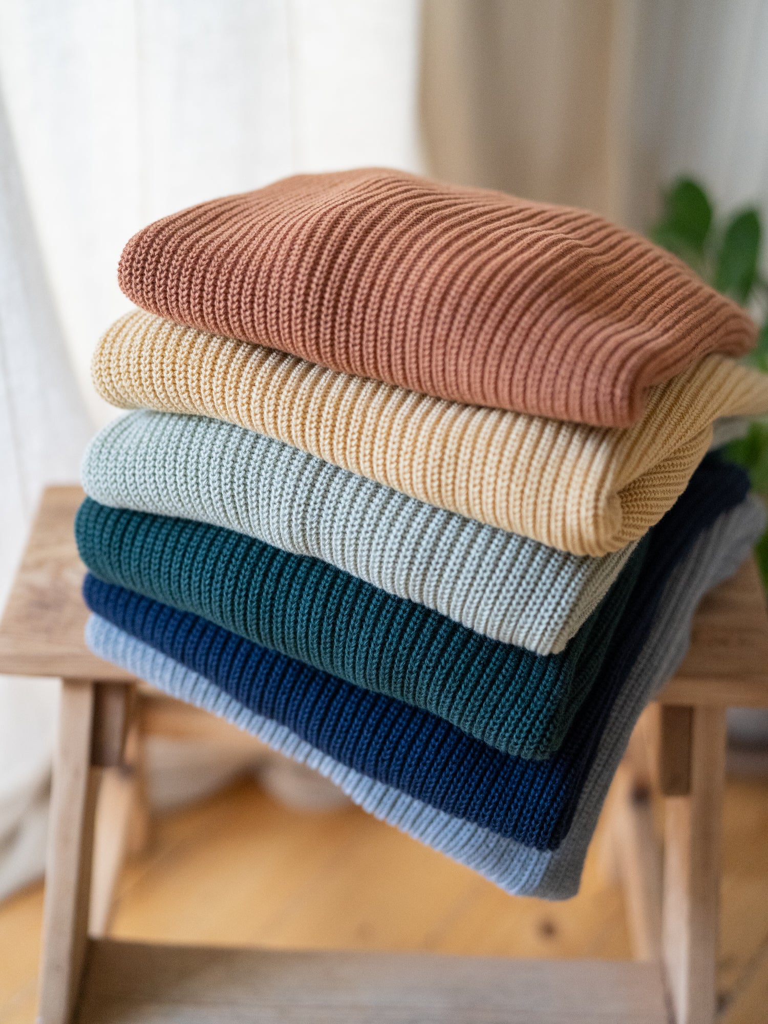 Stapel an verschiedenen FUXBAU Fair Fashion 4Seasons Strickpullover aus Biobaumwolle Made in Italy.