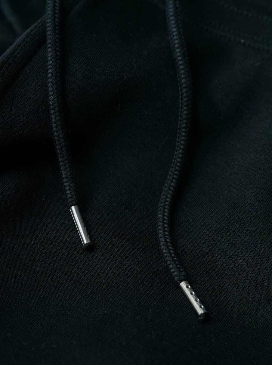 Detailansicht einer nachhaltigen fair fashion Jogginghose von FUXBAU in schwarz und hochwertigen Kordeln aus Biobaumwolle.