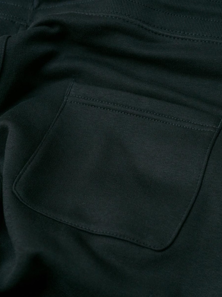 Detailansicht einer nachhaltigen fair fashion Jogginghose von FUXBAU mit weißem fux stick auf grau meliertem Stoff aus Biobaumwolle.