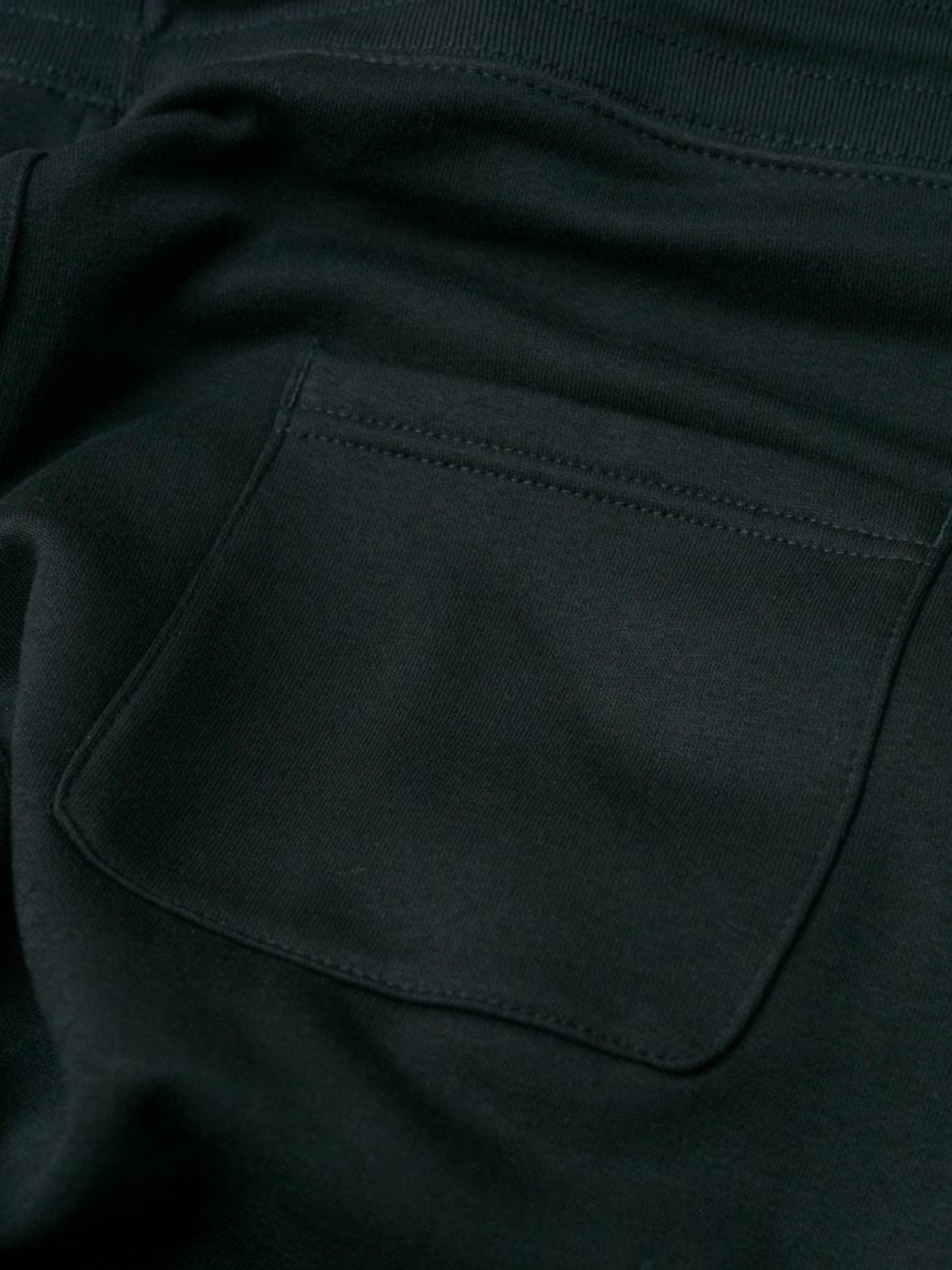 Detailansicht einer nachhaltigen fair fashion Jogginghose von FUXBAU mit weißem fux stick auf grau meliertem Stoff aus Biobaumwolle.