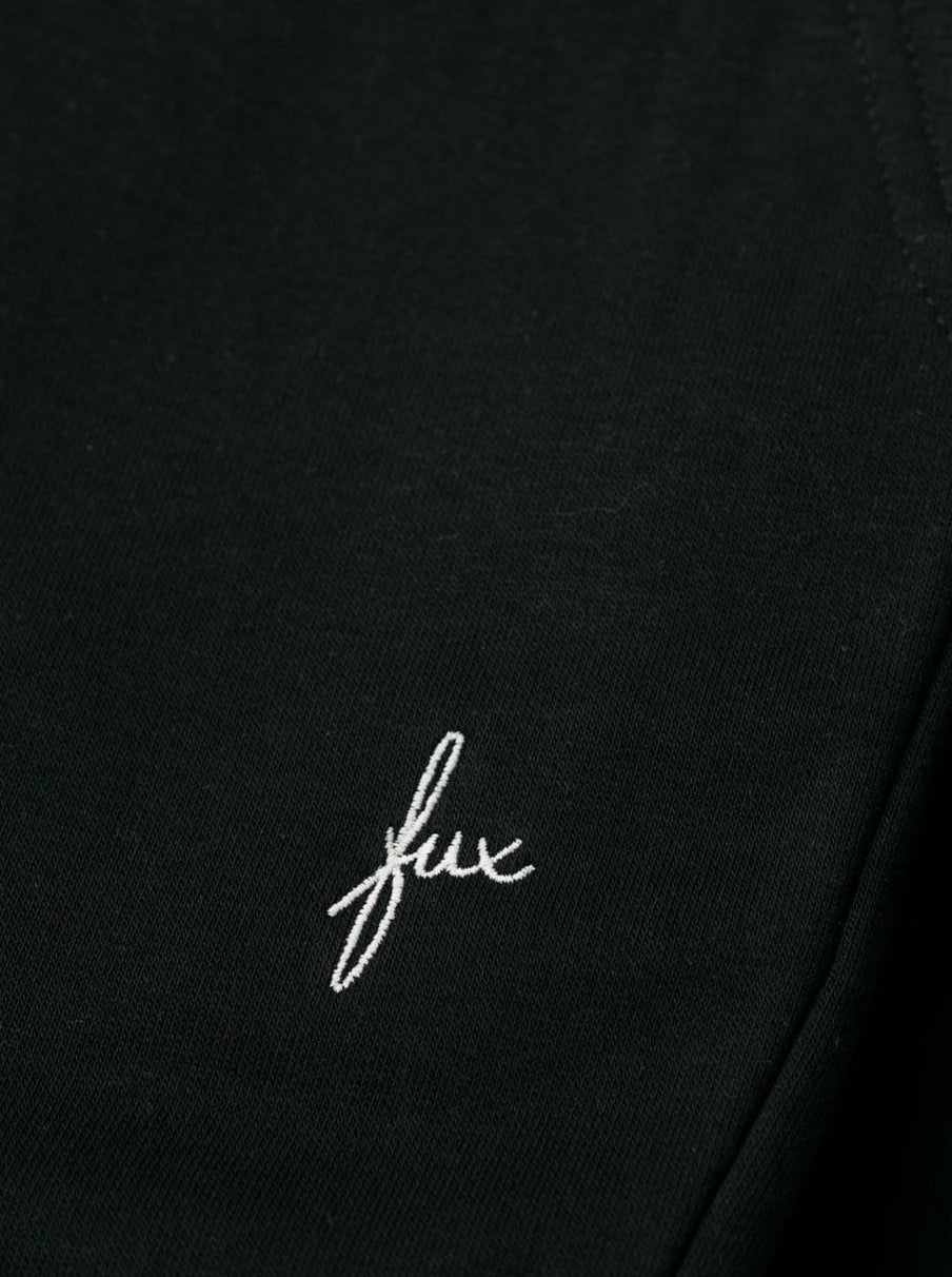 Detailansicht einer nachhaltigen fair fashion Jogginghose von FUXBAU mit weißem fux stick in schwarz aus Biobaumwolle.