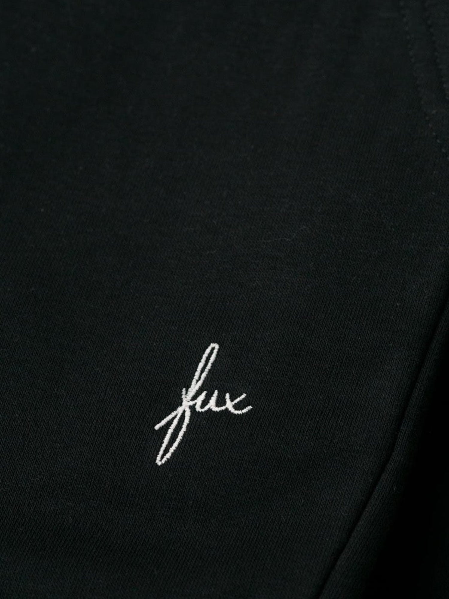 Detailansicht einer nachhaltigen fair fashion Jogginghose von FUXBAU mit weißem fux stick in schwarz aus Biobaumwolle.