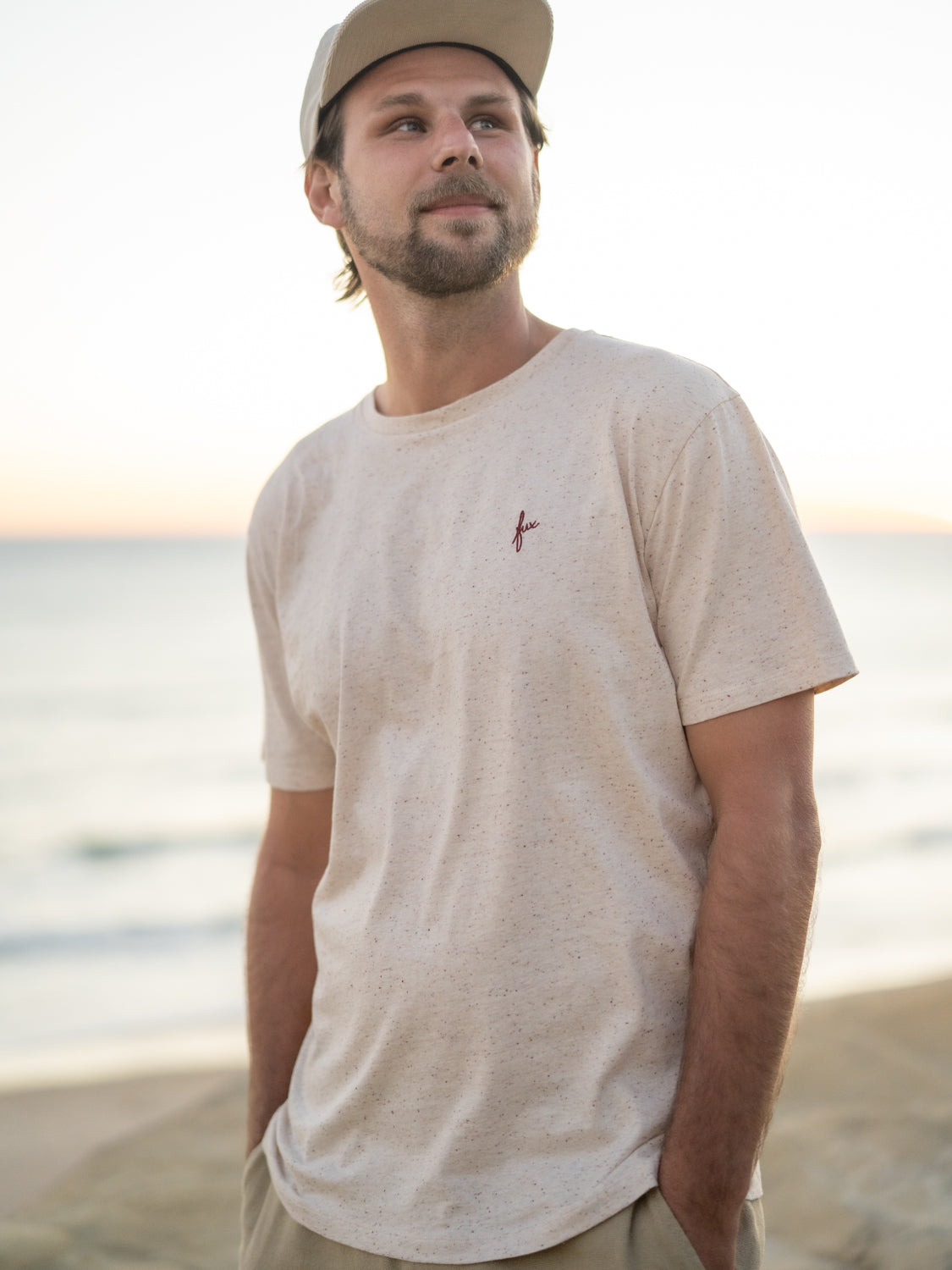 Nachhaltiges highlights T-Shirts in creme mit punkten aus 100% GOTS zertifizierter Biobaumwolle von FUXBAU getragen von Philipp am Strand in Spanien.
