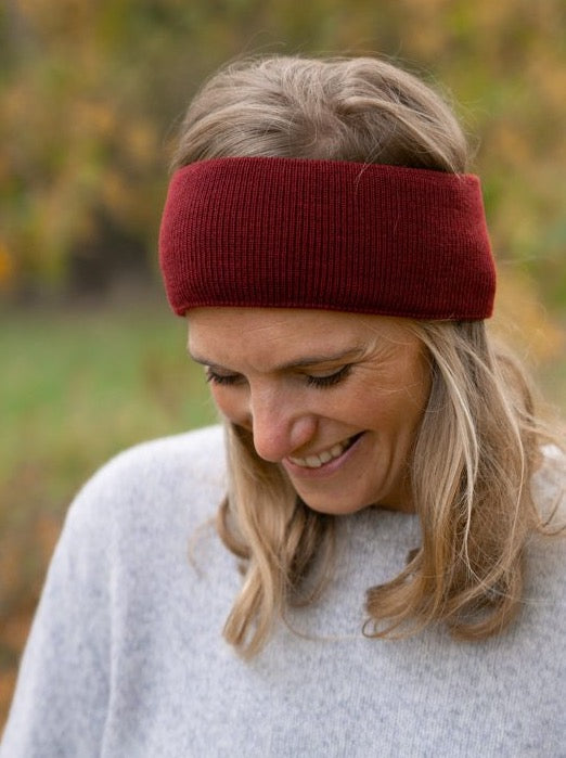Nachhaltig und fair gestricktes Fair Fashion Stirnband von FUXBAU aus 100% GOTS zertifizierter Merino Schurwolle in kirschrot. Gestrick unter fairen und nachhaltigen Bedingungen in Deutschland.
