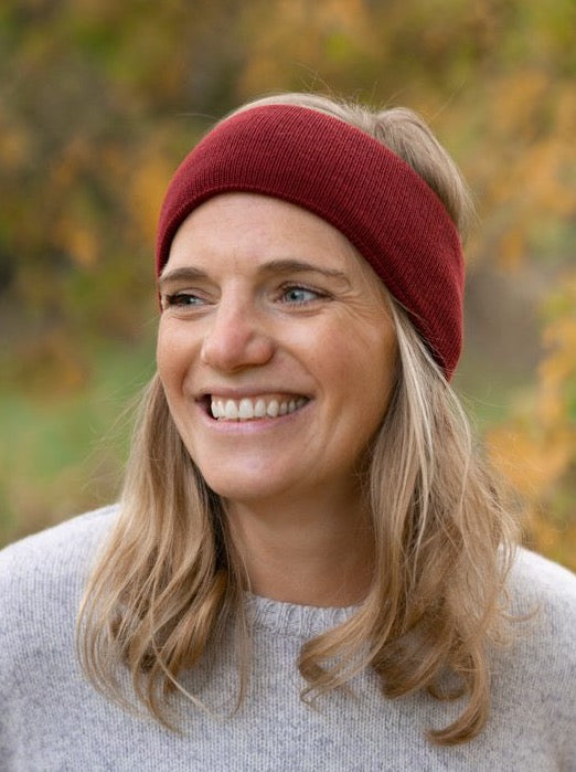 Nachhaltig und fair gestricktes Fair Fashion Stirnband von FUXBAU aus 100% GOTS zertifizierter Merino Schurwolle in kirschrot. Gestrick unter fairen und nachhaltigen Bedingungen in Deutschland.