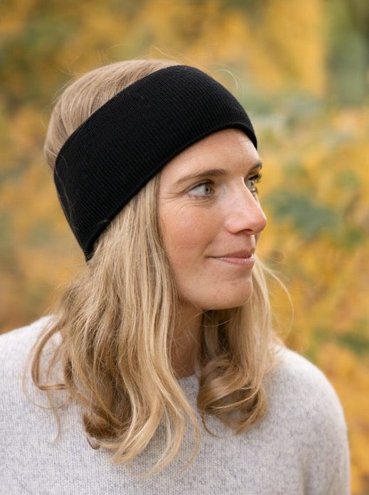 Unser Model Isi trägt unser extra warmes und weiches Merino Stirnband in schwarz aus 100% GOTS zertifizierter Merino Schurwolle.