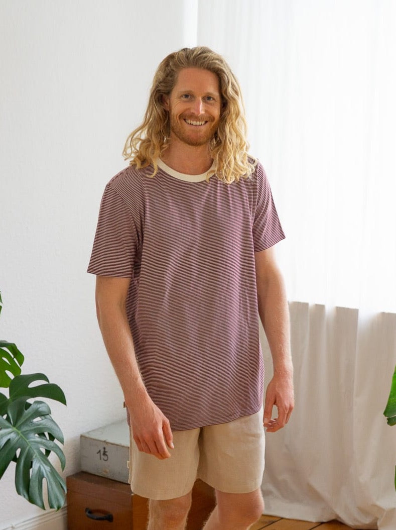 Mo trägt unser Fair Fashion Männer Streifenshirt in creme bordeaux aus 100% GOTS zertifizierter Biobaumwolle