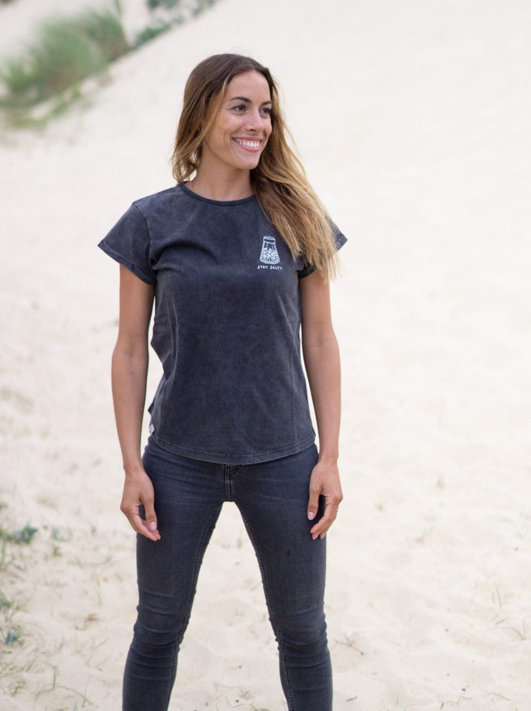 Rachel trägt unser Stay Salty Frauen T-Shirt im Urlaub am Strand