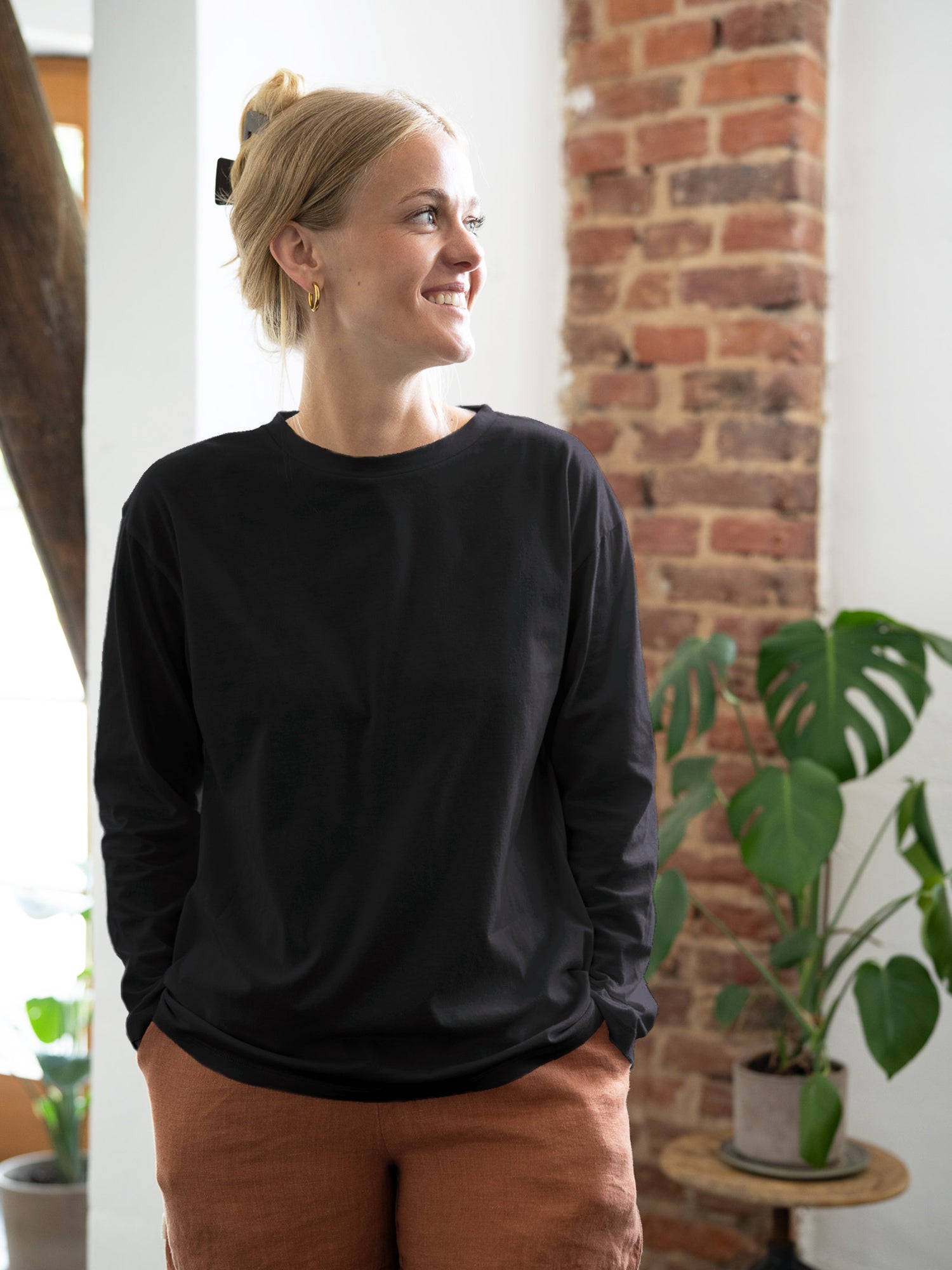 Greta trägt das nachhaltige und faire Frauen Basic Langarmshirt in schwarz aus 100% GOTS zertifizierter Biobaumwolle made in Portugal