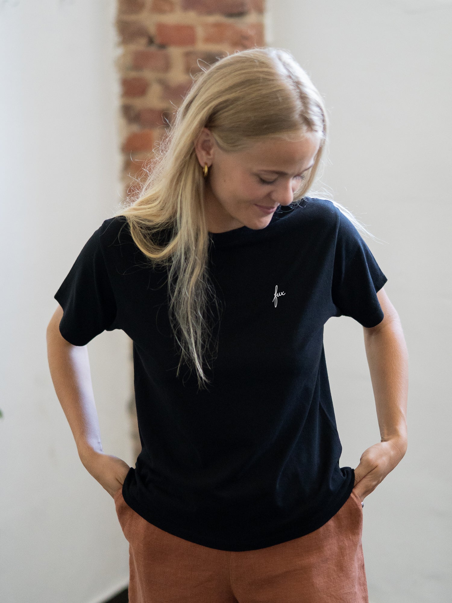 Greta trägt das Frauen fux Basic T-Shirt - schwarz als B-Ware. Qualität zum fairen Preis. Durch einen Missverständnis ind er Kommunikation mit unseren Partnern hat das FUXBAU Frauen Basic T-Shirt unseren fux Stick erhalten.