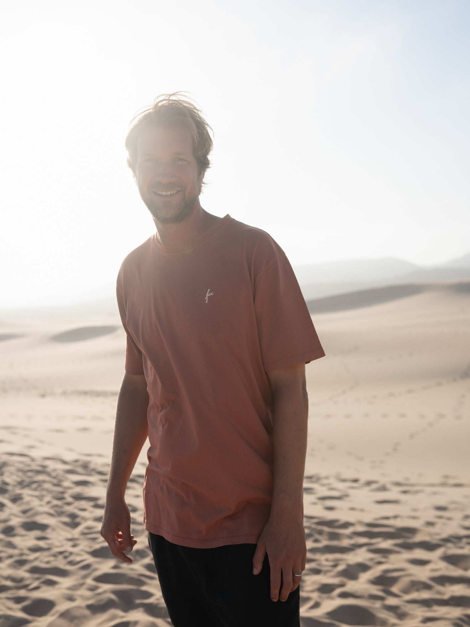 Mann trägt fair gefertigtes rotes FUXBAU T-Shirt aus Biobaumwolle in Portugal