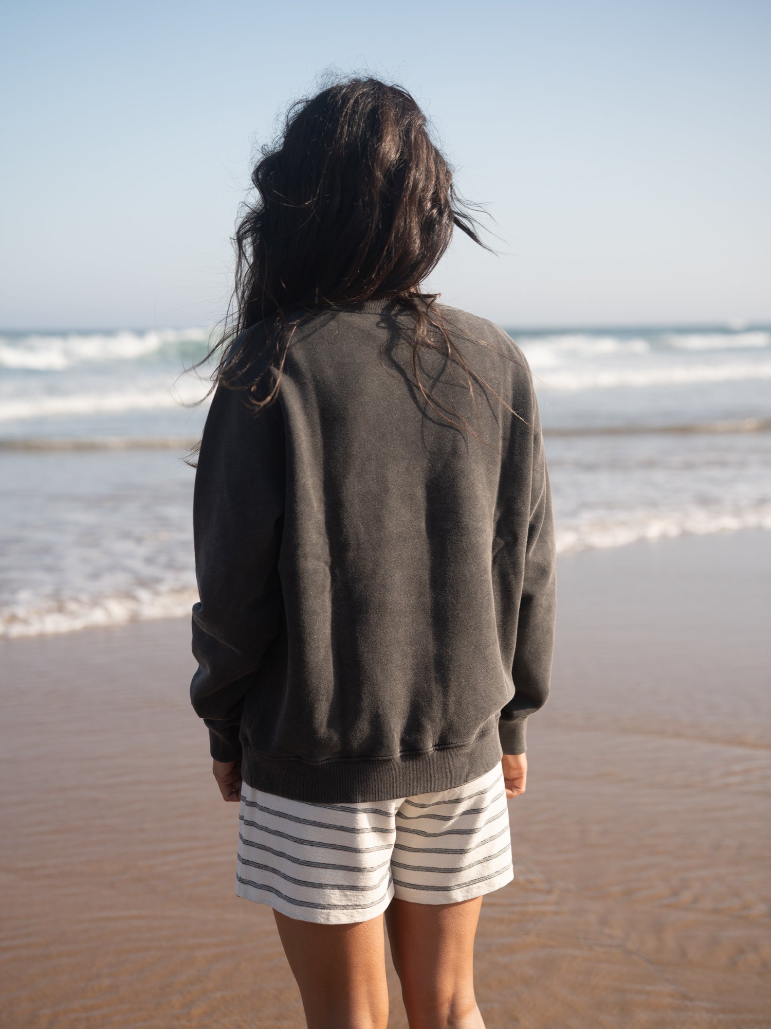 Rückansicht des Frauen Stay Salty Sweaters am Meer