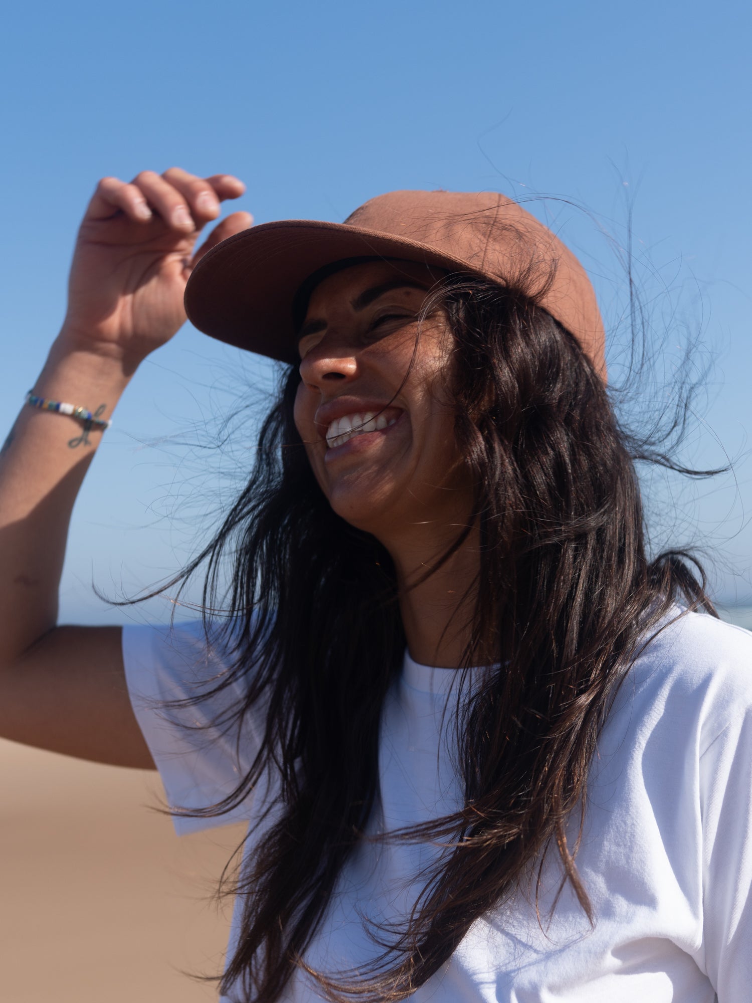 Frau mit kastanie farbenen Unisex Dad Cap am Strand