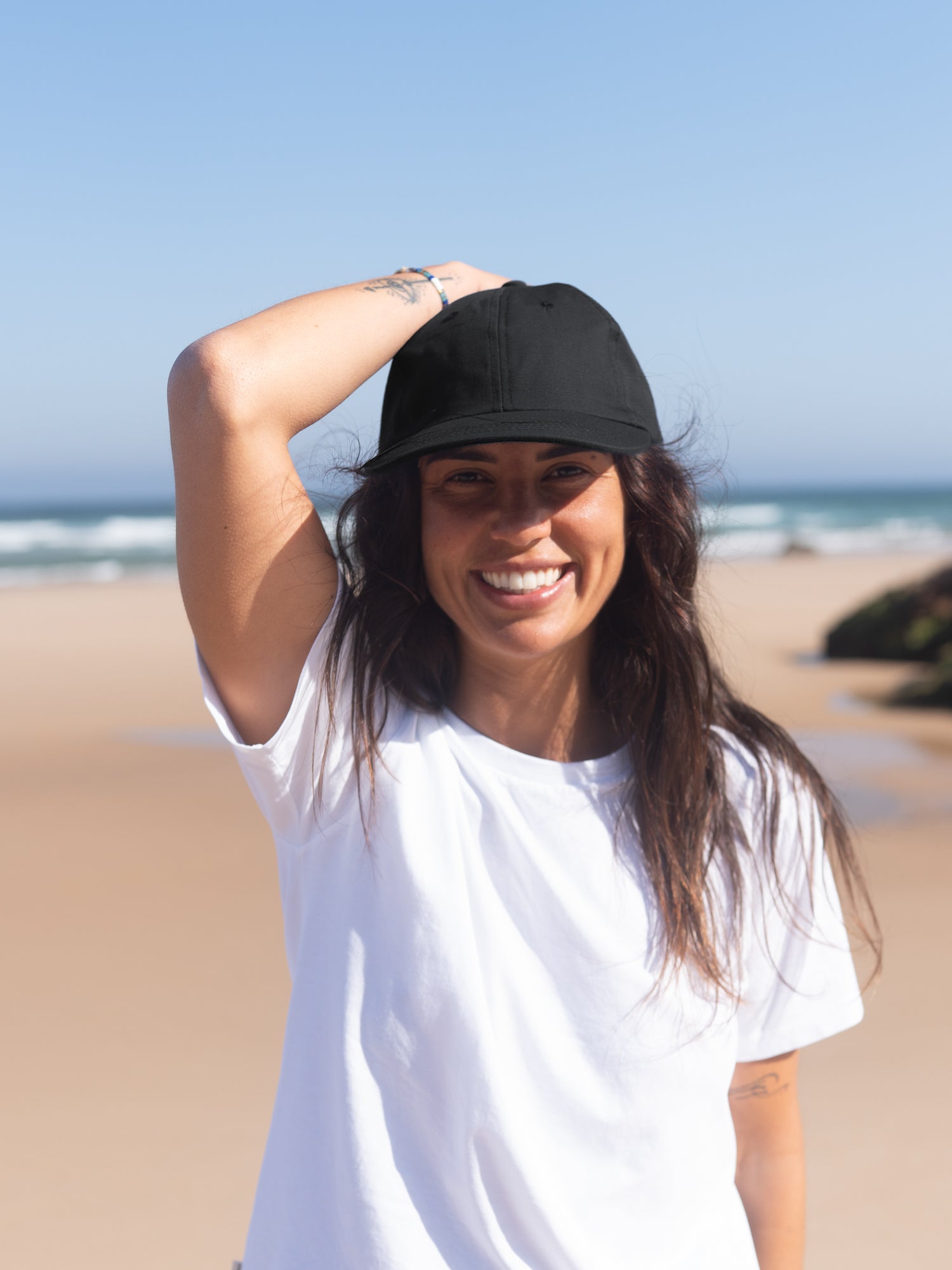 Frau mit schwarzer nachhaltiger Unisex Dad Cap am Strand