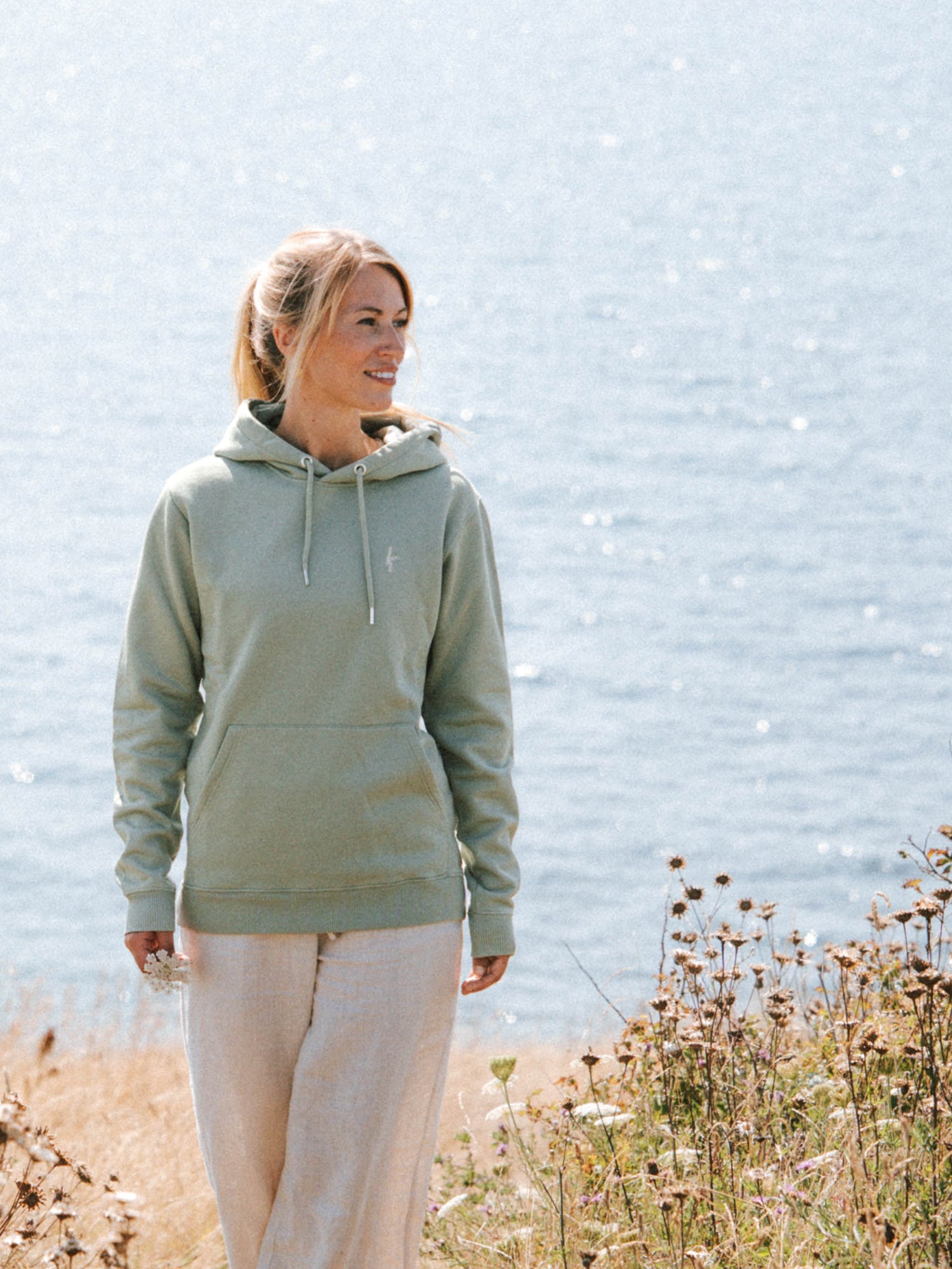 Unisex Hoodie in Seegras aus Biobaumwolle mit Kapuze und Kängurutasche am Meer