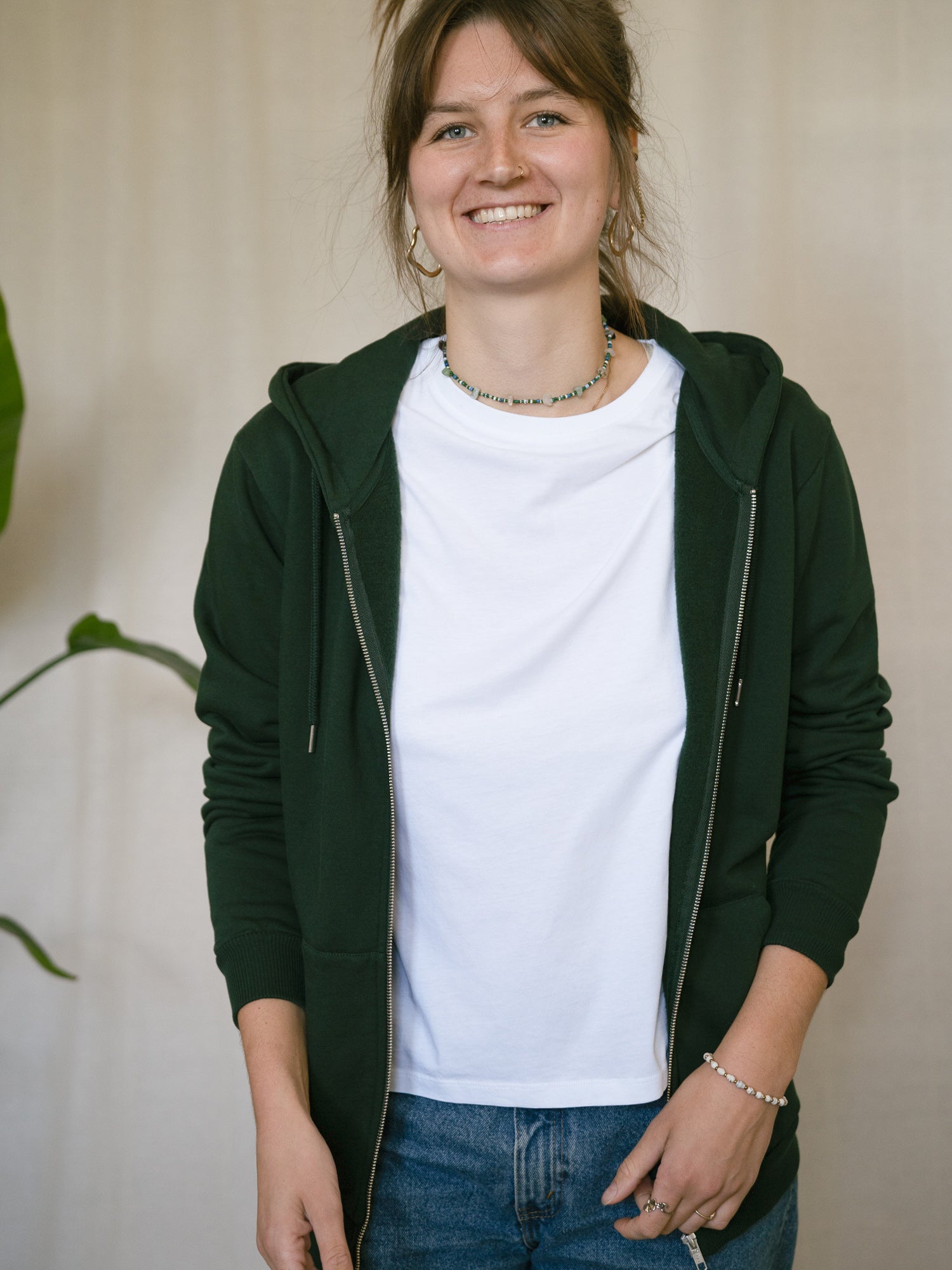 FUXBAU Sweatjacke Frauen grün – Modell trägt geöffnete Kapuzenjacke über weißem T-Shirt, fair in Portugal hergestellt