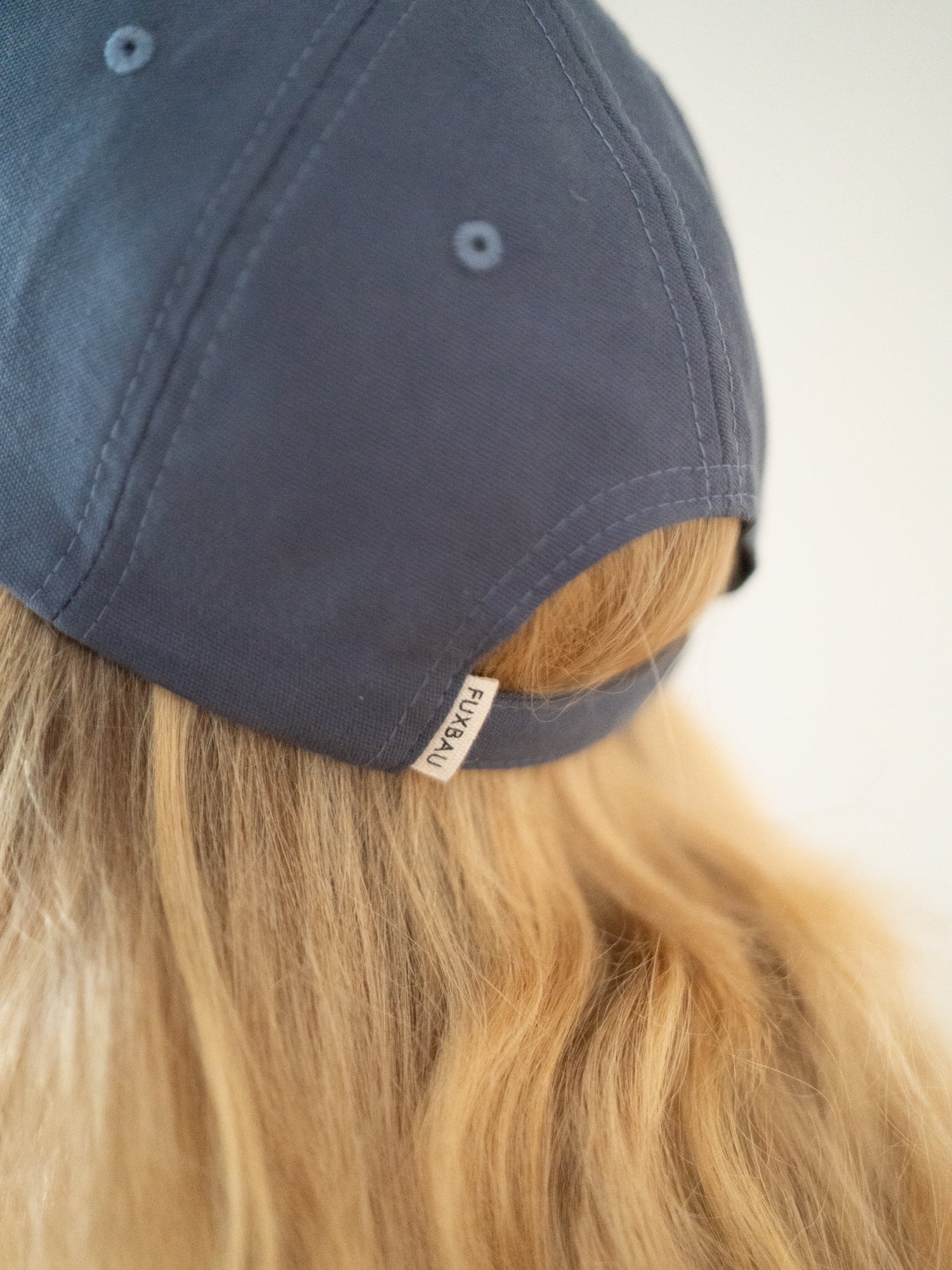 Unisex Dad Cap in blaugrau getragen von einer blonden Frau