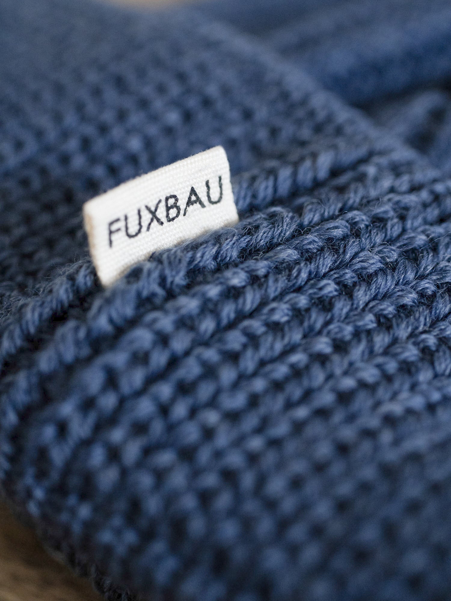 Detailaufnahme der FUXBAU Sideflag der kurzen Merino Fischermütze in nachtblau, GOTS zertifiziert und made in Germany