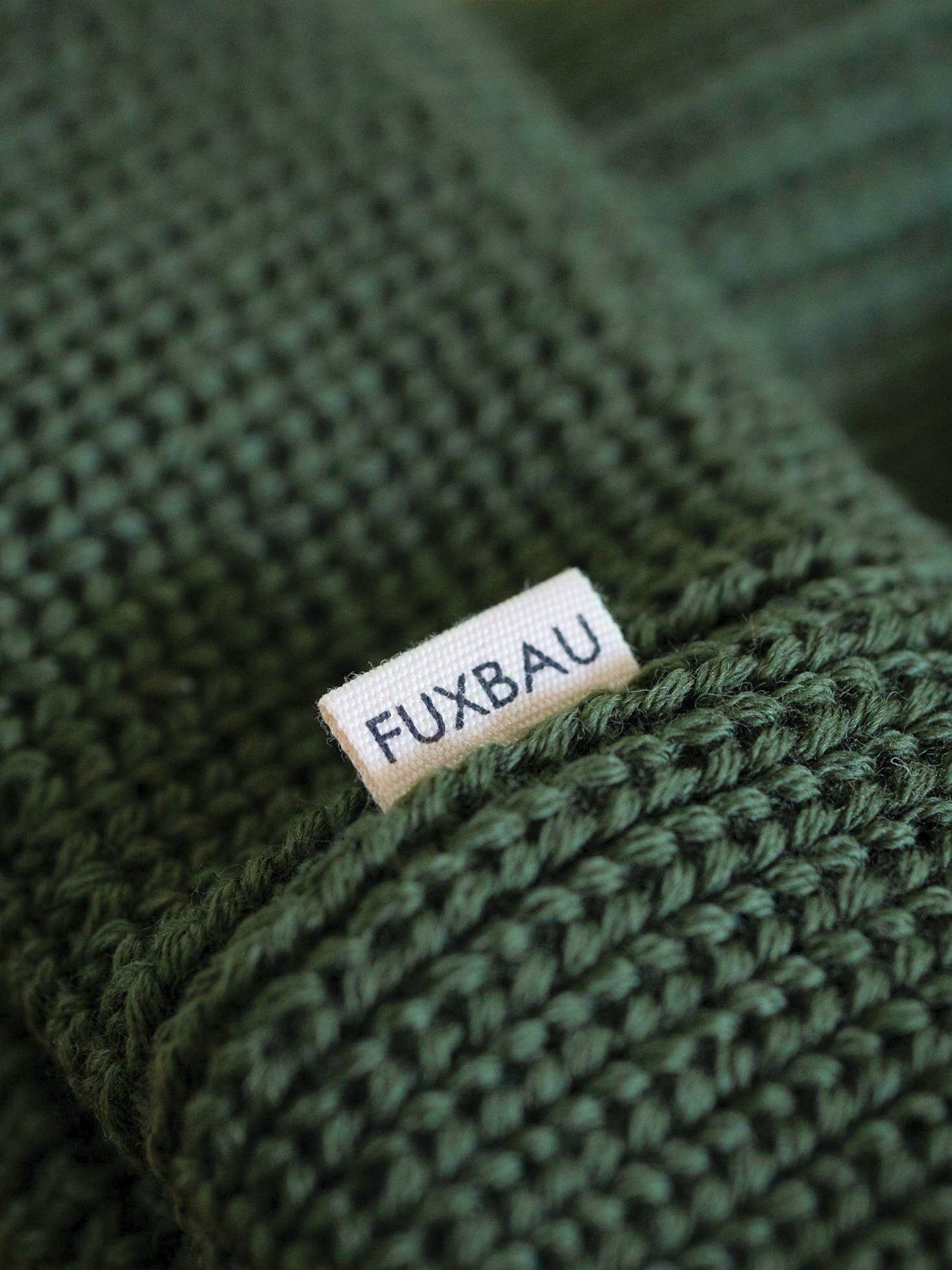 Detailaufnahme der FUXBAU Sideflag der kurzen Merino Fischermütze in waldgrün, GOTS zertifiziert und made in Germany