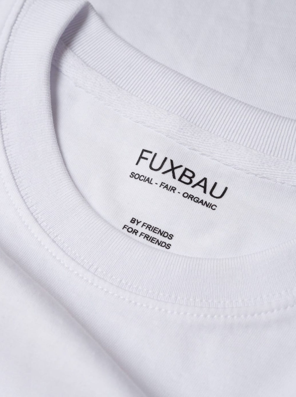 Detailbild eines nachhaltiges FUXBAU Basic T-Shirt in weiß mit einem schwarzen Imprint. Gefertigt aus 100% Biobaumwolle aus unserem 3er Pack..