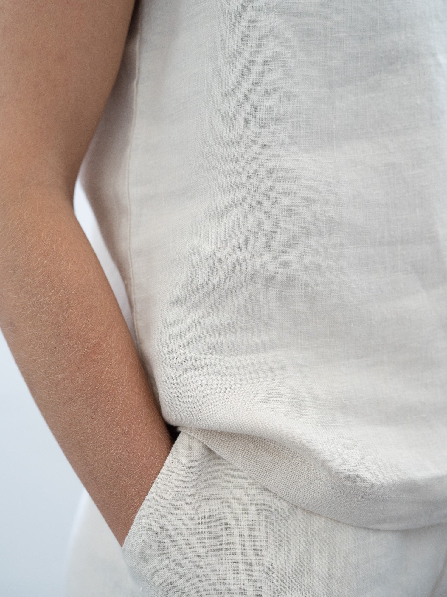 Luftiges Leinentop in cremeweiß für Frauen von FUXBAU, perfekt für die warmen Tage, 100% Leinen & Made in Portugal. Getragen von einer jungen, blonden Frau.