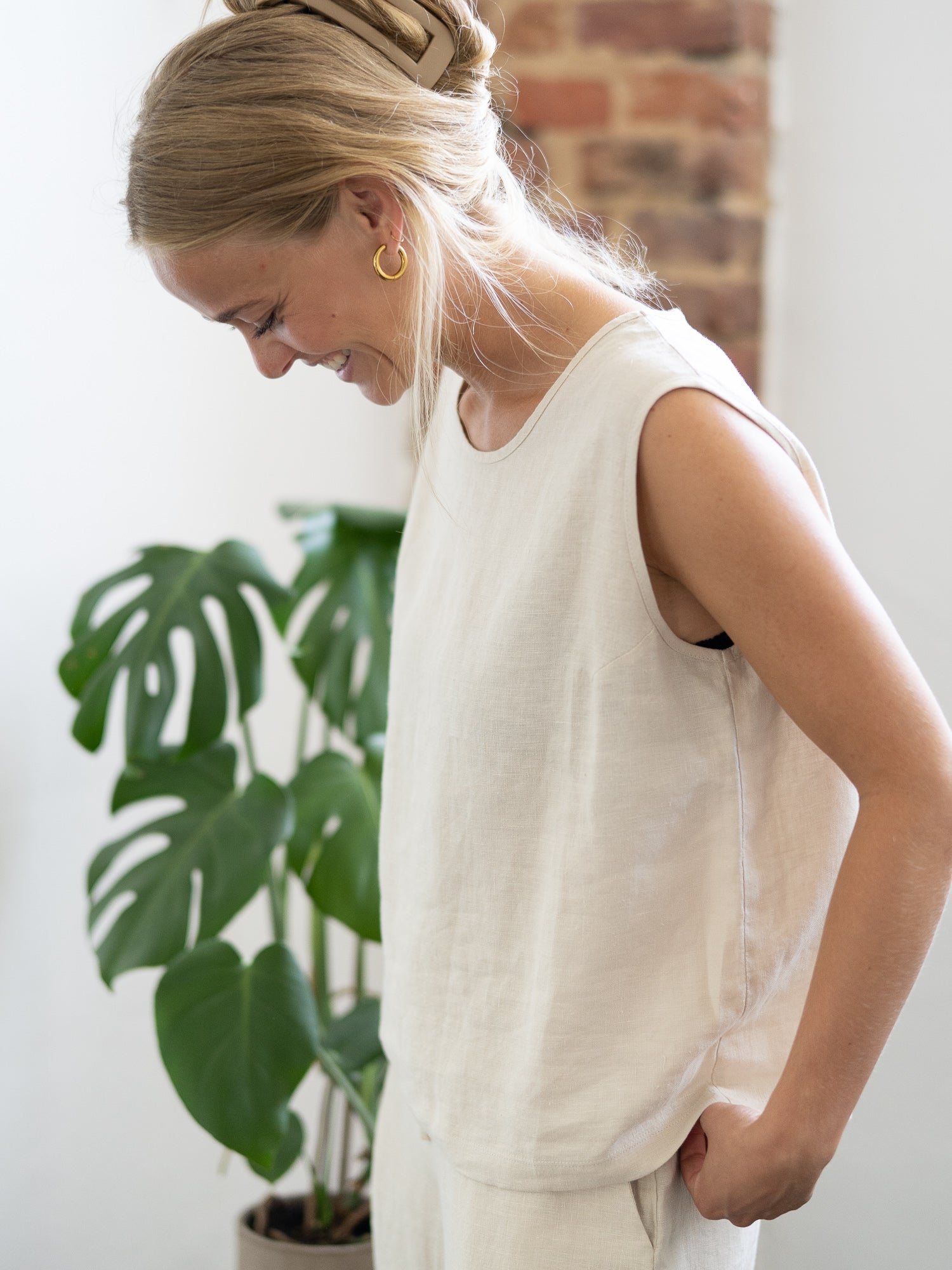 Luftiges Leinentop in cremeweiß für Frauen von FUXBAU, perfekt für die warmen Tage, 100% Leinen & Made in Portugal. Getragen von einer jungen, blonden Frau.