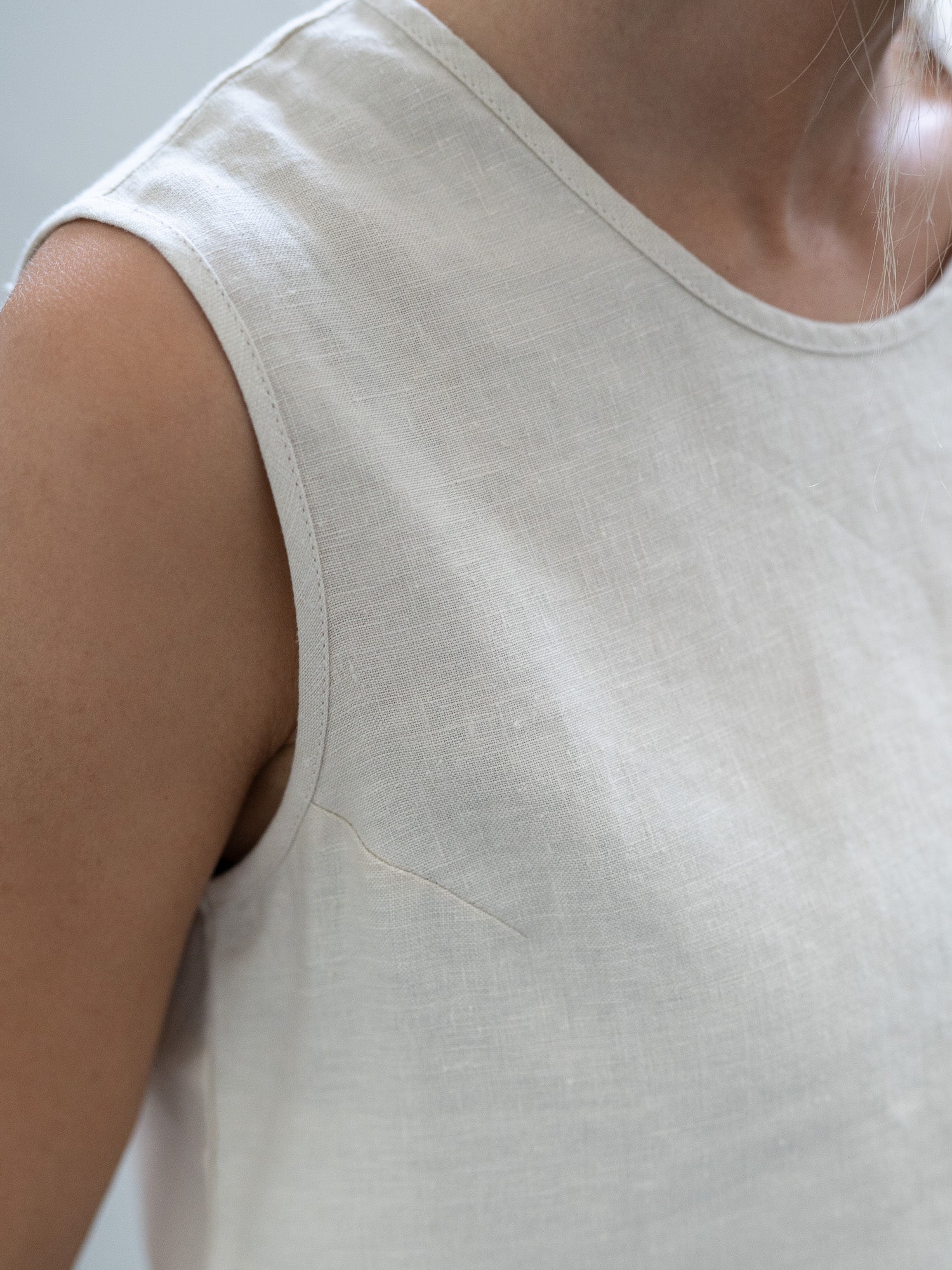 Luftiges Leinentop in cremeweiß für Frauen von FUXBAU, perfekt für die warmen Tage, 100% Leinen & Made in Portugal. Getragen von einer jungen, blonden Frau.