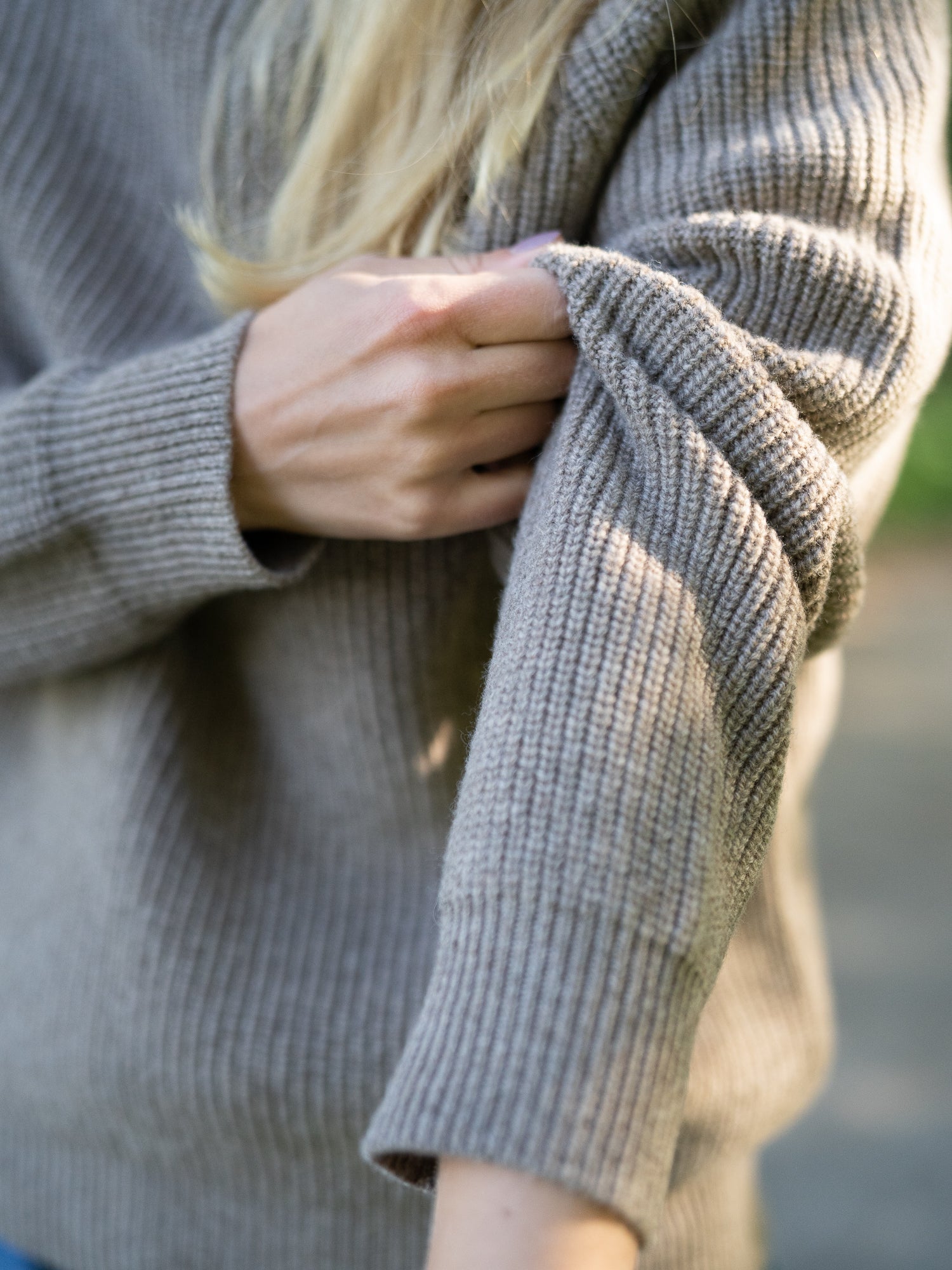 Nachhaltiger Fair Fashion Frauen Merino Troyer in braun meliert aus 100% Merino Schurwolle in navy Made in Italy, getragen von einer jungen Frau.