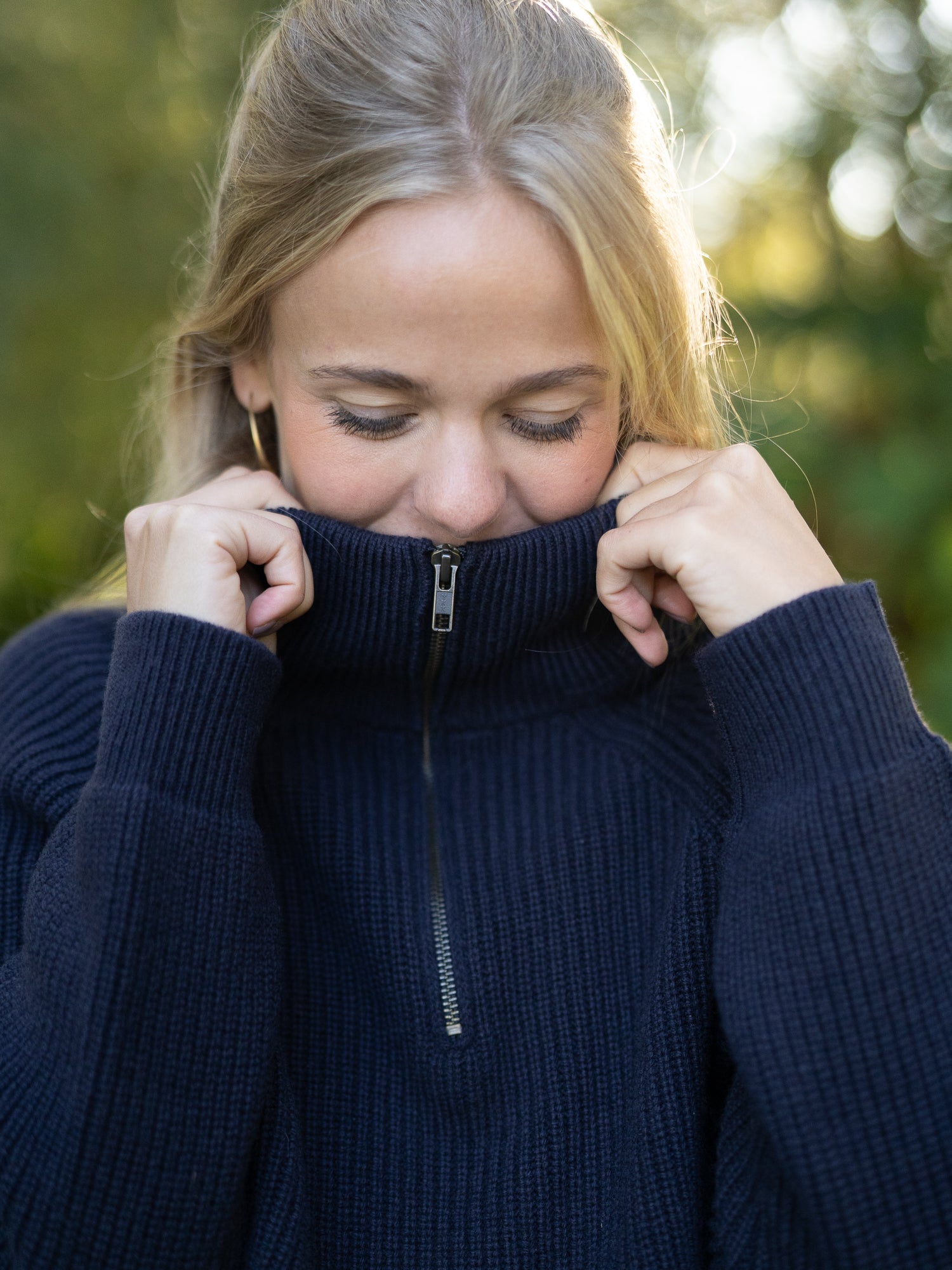 Nachhaltiger Fair Fashion Frauen Merino Troyer in navy aus 100% Merino Schurwolle in navy Made in Italy, getragen von einer jungen Frau.