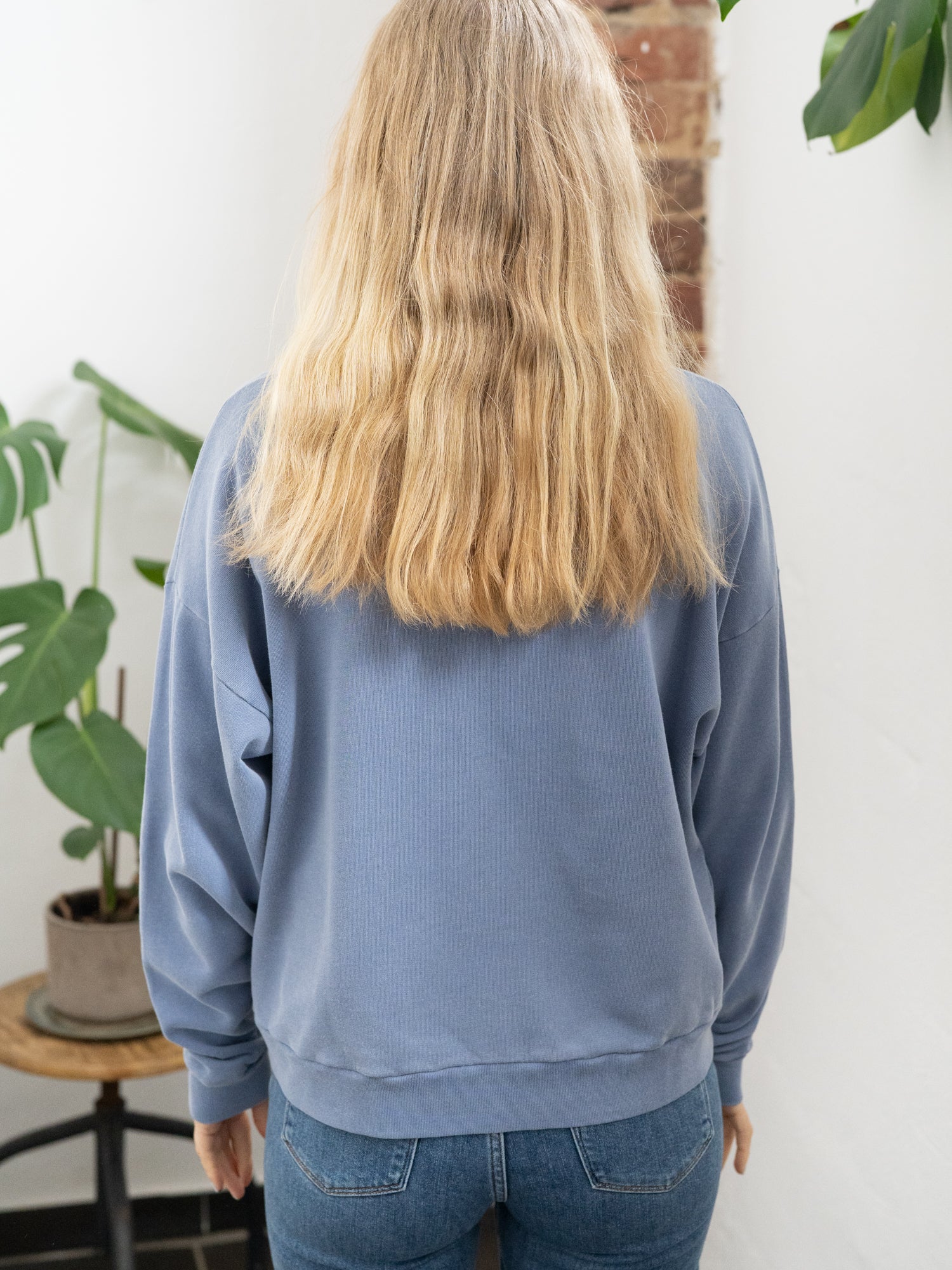 Nachaltiger Fair Fashion Oversize Pulloer von FUXBAU in blau, gefärbt mit naturfarben und getragen von einer jungen blonden Frau.
