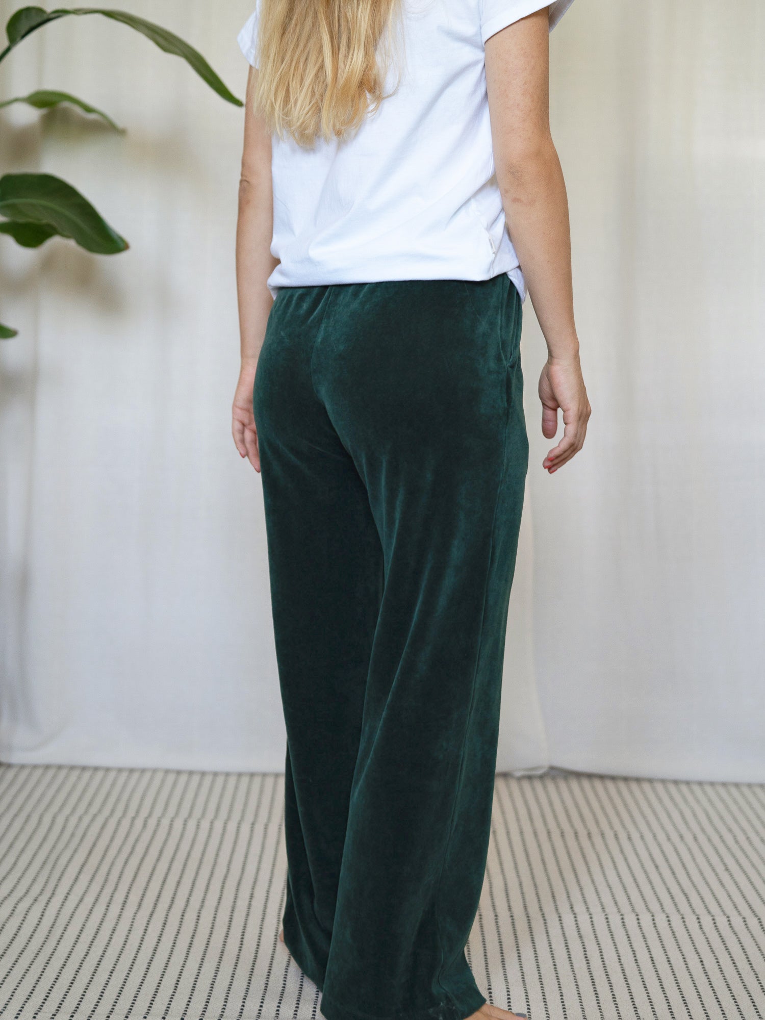 Rückansicht der dunkelgrünen FUXBAU Samthose Greta – Fair Fashion Hose für Frauen aus Biobaumwolle, nachhaltig und bequem.