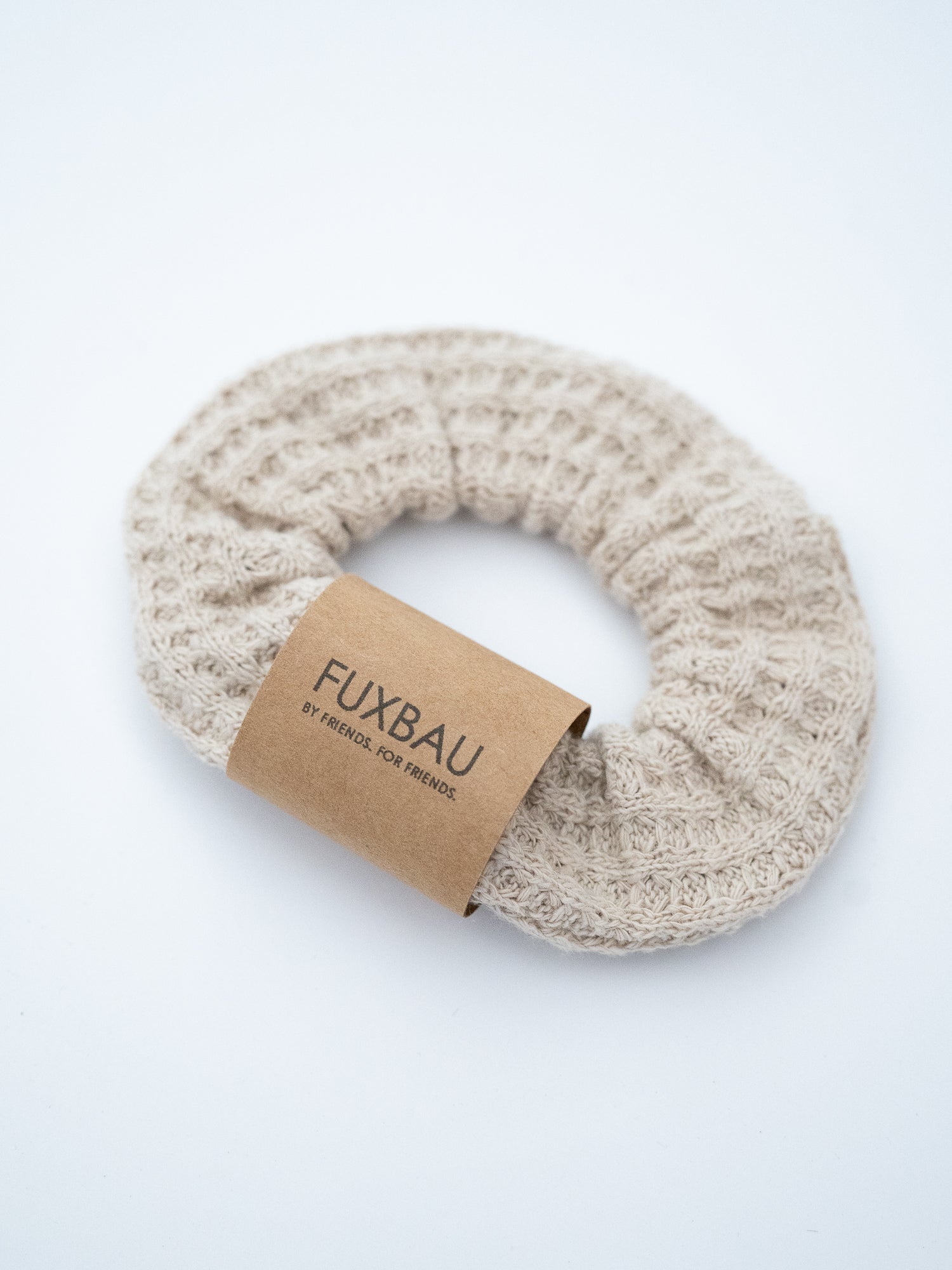 Beiger Scrunchie aus Waffelstrick von FUXBAU – seitliche Ansicht des nachhaltigen Haargummis aus fairer Produktion.

