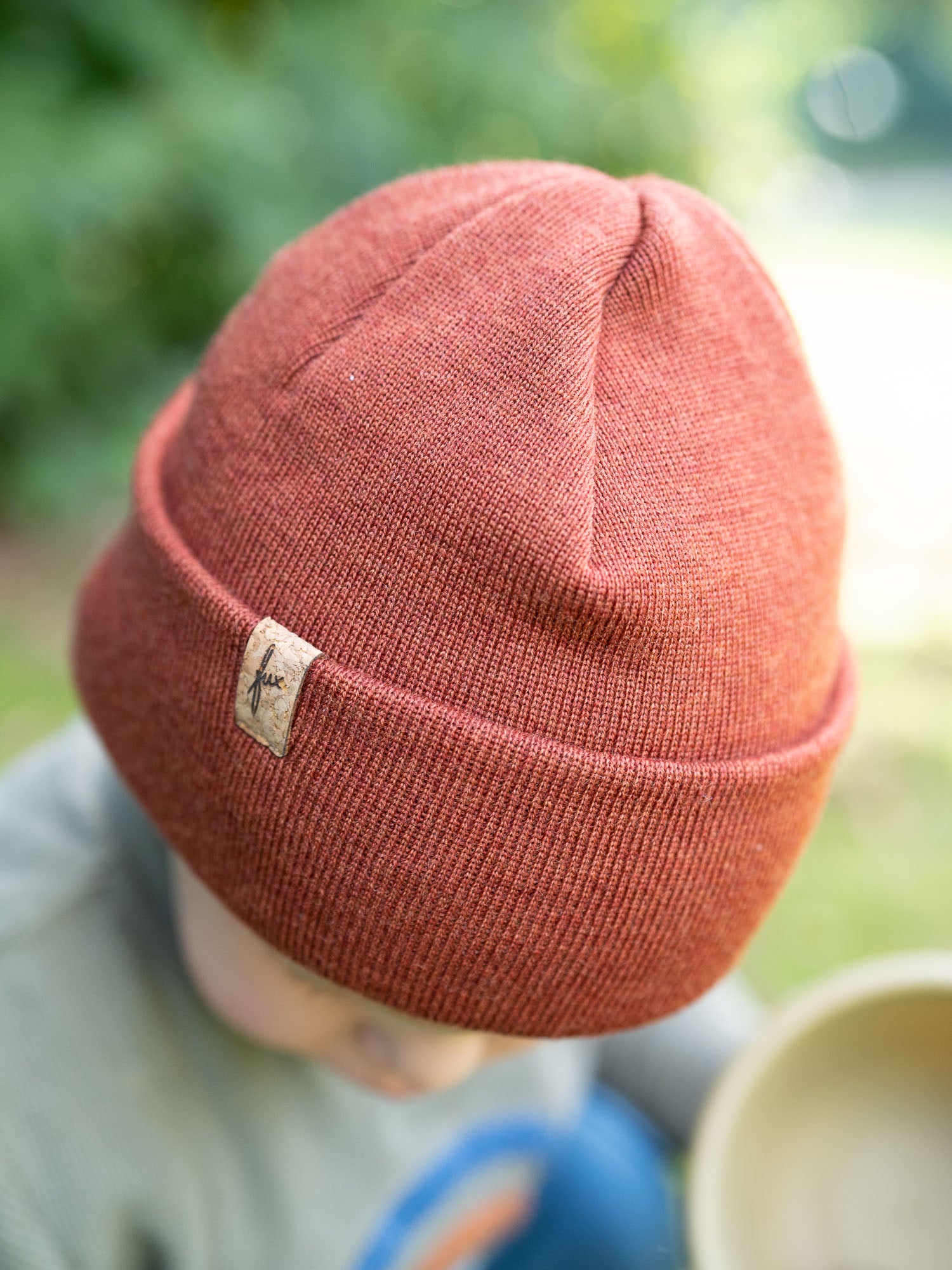 Detailansicht Kind mit herbstorangener FUXBAU Kinder Merino Kork Beanie – nachhaltige Kindermütze aus Merinowolle, fair gefertigt in Deutschland.