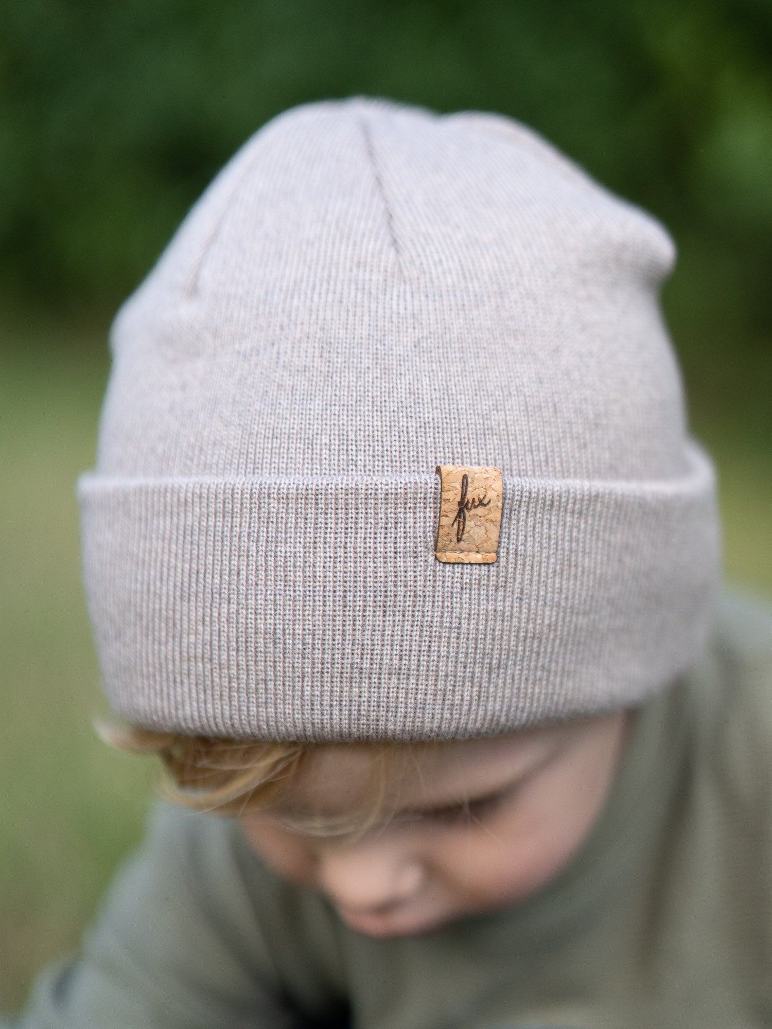 Detailaufnahme der sandfarbenen Kinder Merino Kork Beanie von FUXBAU mit Kork-Logo – Fair Fashion aus Merinowolle, hergestellt in Deutschland.