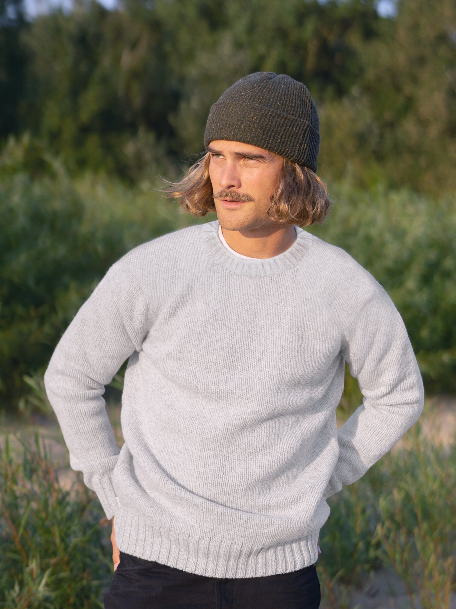 Kelsey trägt unseren Nachhaltiger Männer Merino Strickpullover in grau aus 100% Merinowolle und fair in Deutschland hergestellt