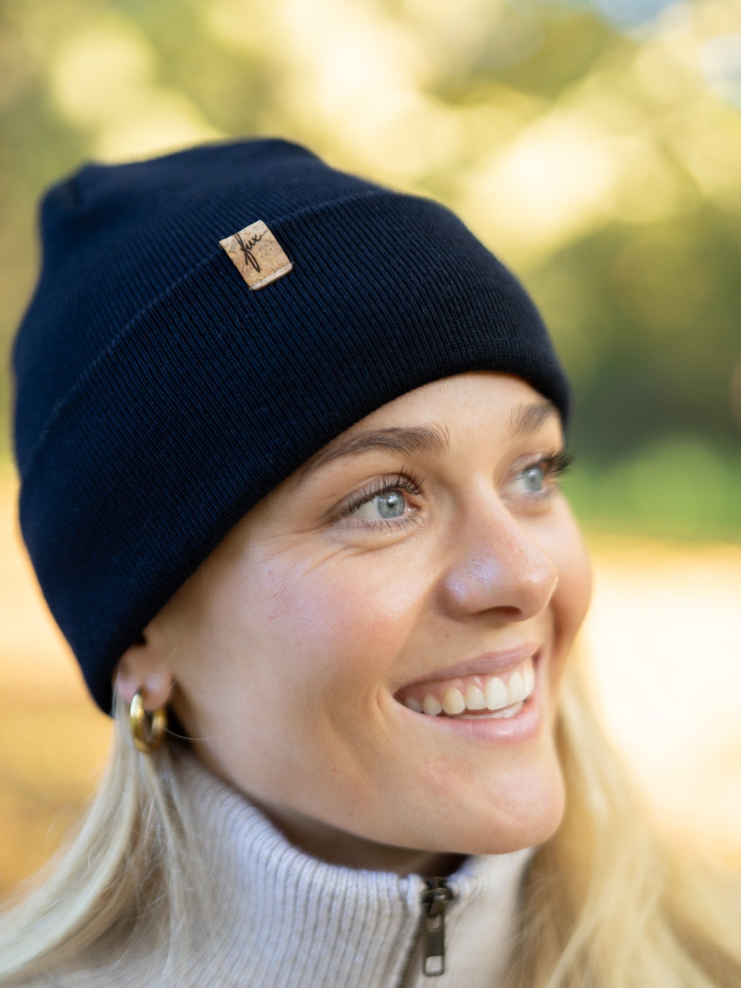 Nachhaltige Fair Fashion Merino Kork Beanie in navy von FUXBAU. Getragen von einer jungen, blonden Frau im Herbst in Münster.