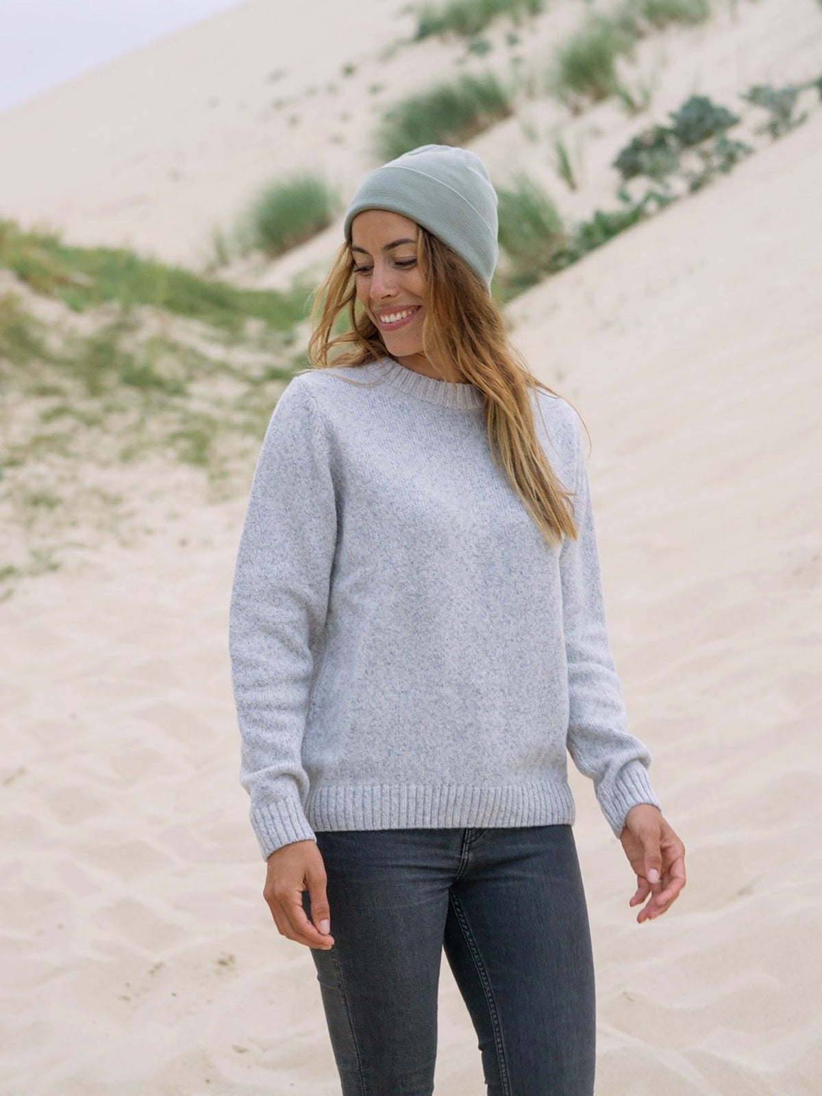 Rachel trägt unseren Merino Strickpullover in graumeliert aus 100% Merinowolle