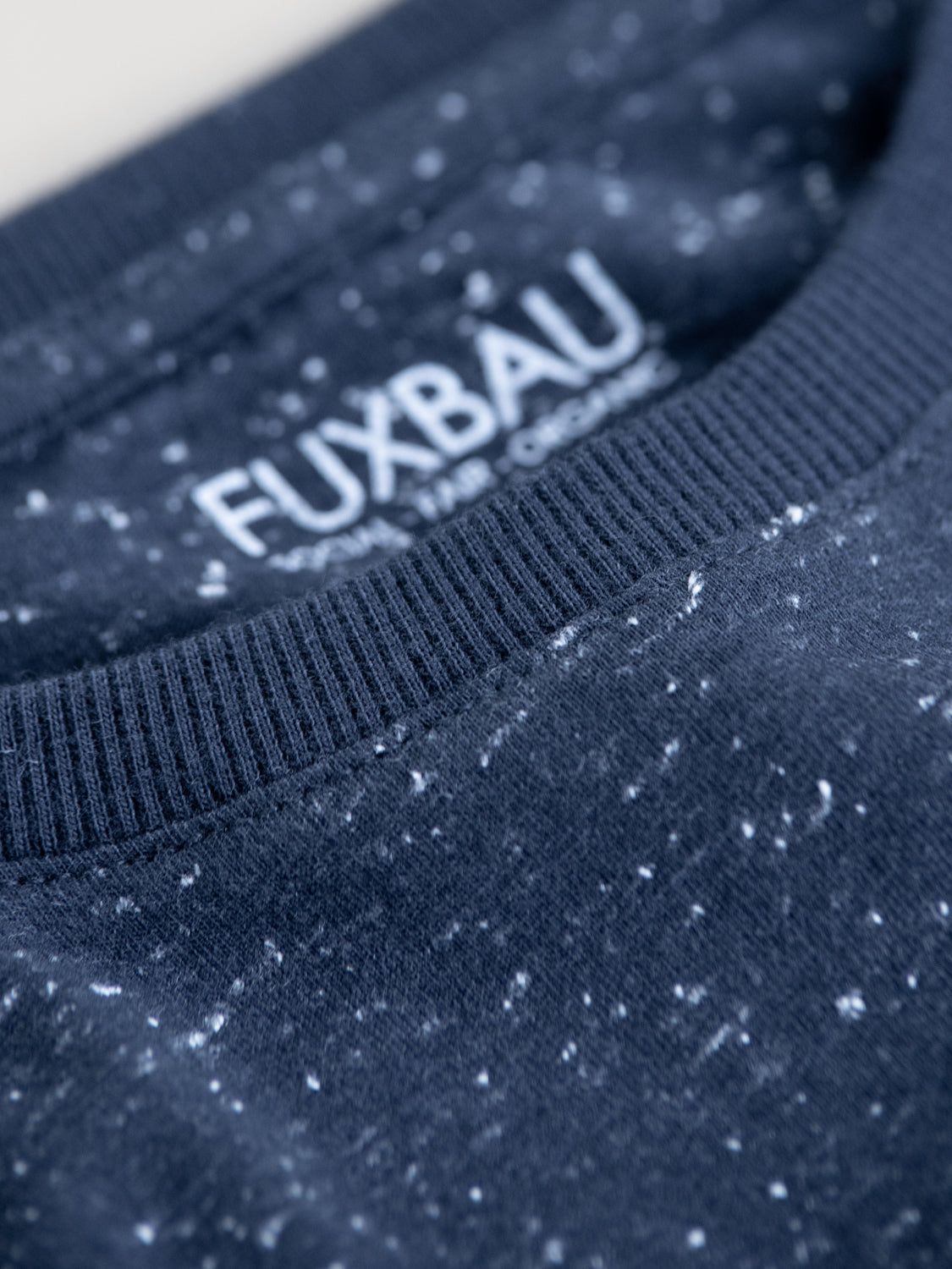 Detailansicht unseres Fair Fashion Fuxbau T-Shirt in navy mit weißen Punkten aus GOTS zertifizierter Biobaumwolle. Gefertigt unter fairen und nachhaltigen Bedinungen in Portugal und inspiriert durch die Schönheit der Ozeane.