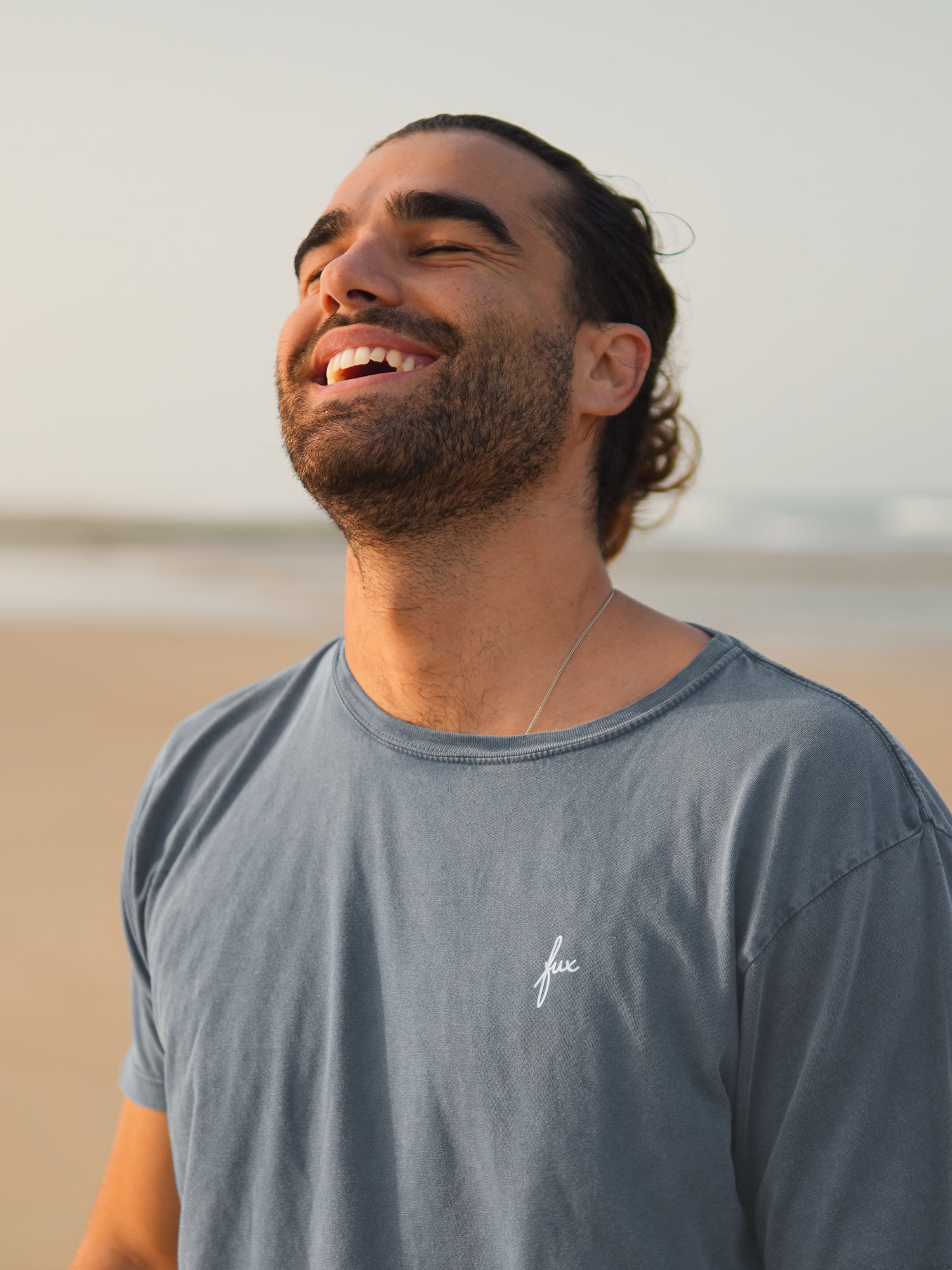 Unser Freund Guillermo trägt das nachhaltige Männer Natural DyT-Shirt in blaugrau am Strand