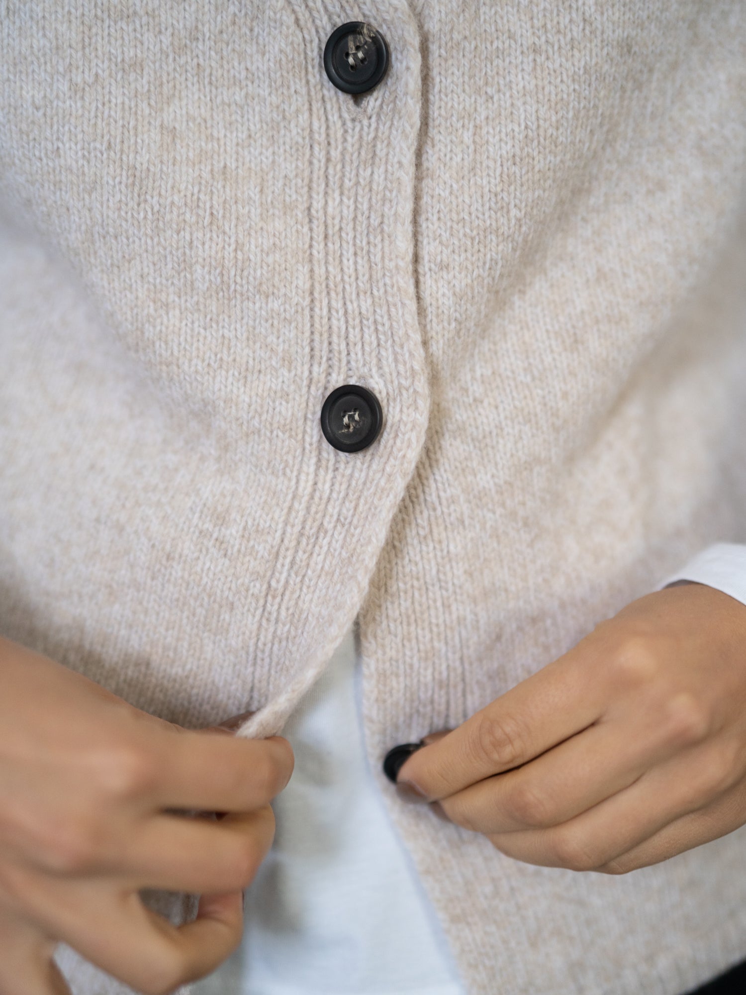 Detailaufnahme der FUXBAU Strickweste aus Merinowolle – hochwertige Knöpfe und feine Strickstruktur in Beigemeliert