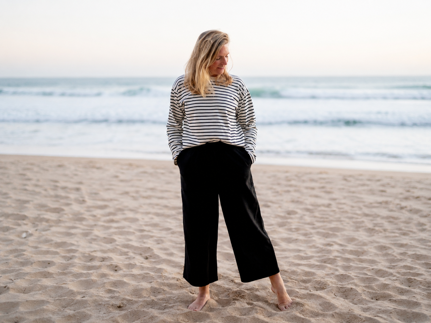 Isi trägt eine luftige und atmungsaktive Leinenhose an einem heißem Sommertag am Strand