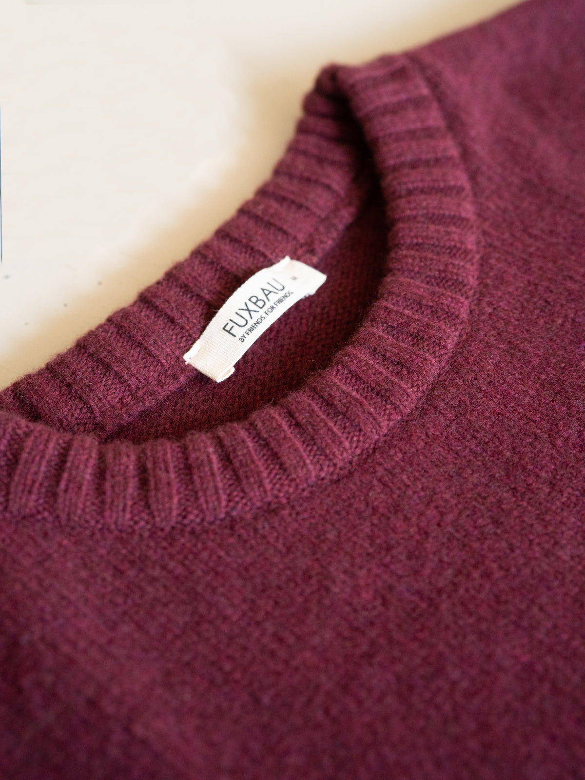 Bordeauxfarbener Merino Strickpullover mit Rundhalsausschnitt und FUXBAU Label in Detailansicht