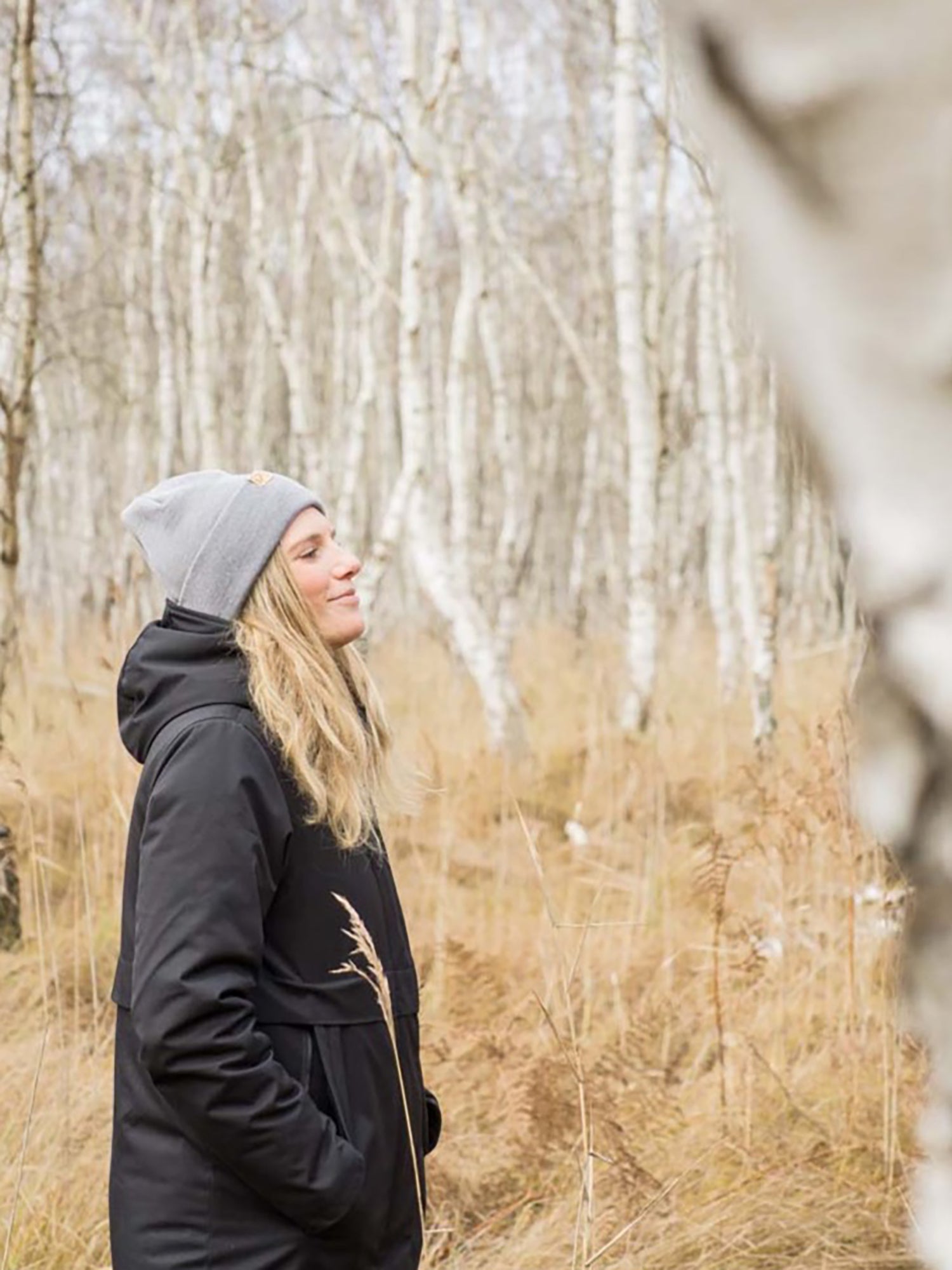Unsere Freundin Isi trägt unseren Fuxbau Merino Beanie in grau in einem Birkenwald an der Ostsee. Regional in Norddeutschland unter fairen Bedingungen mit Liebe zum Detail gefertigt.