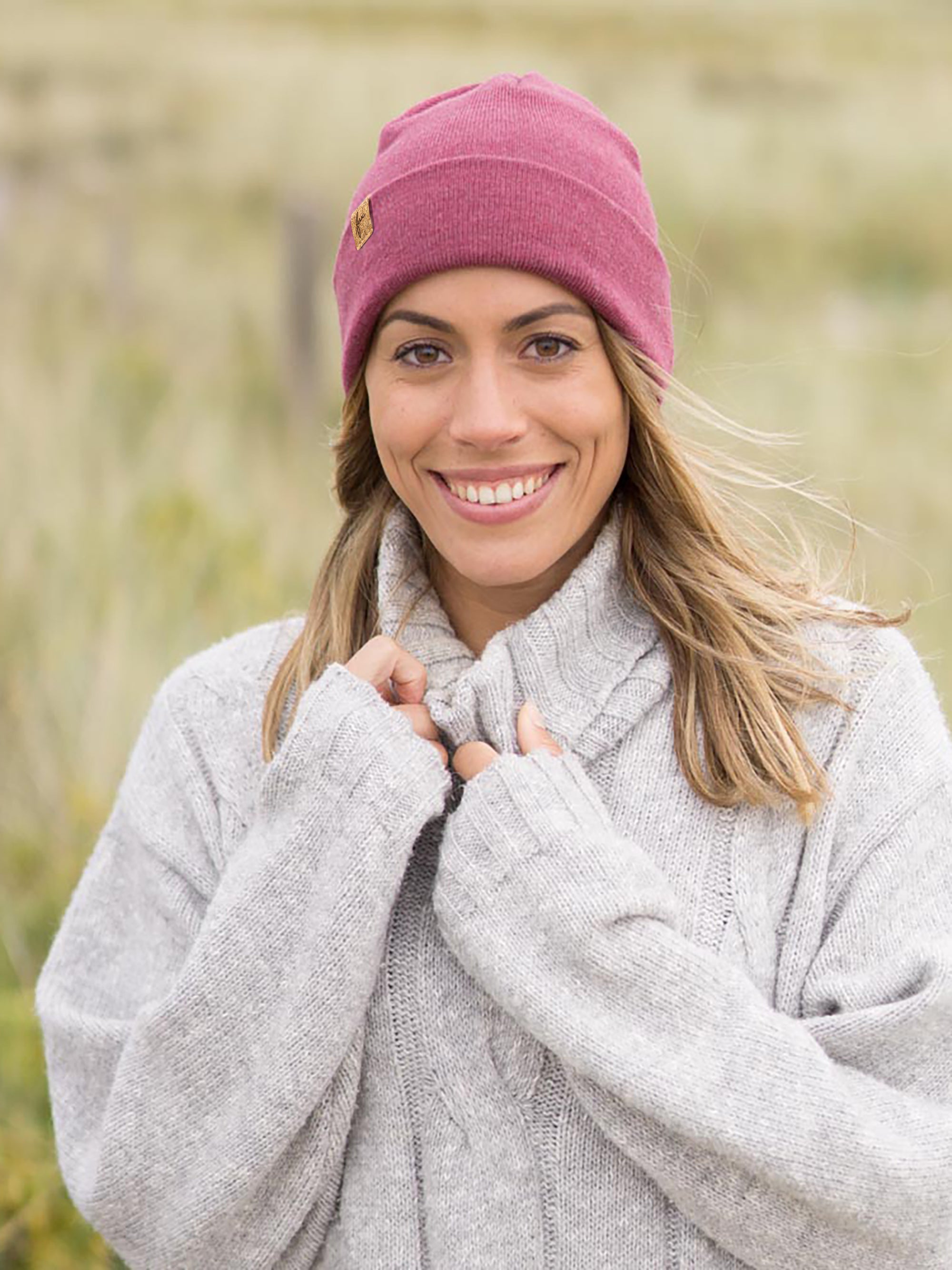 Merino-Kork Beanie Himbeere – warme Beanie-Mütze aus Merinowolle mit Kork-Label, fair produziert in Deutschland, Modell kuschelt sich in grauen Strickpullover