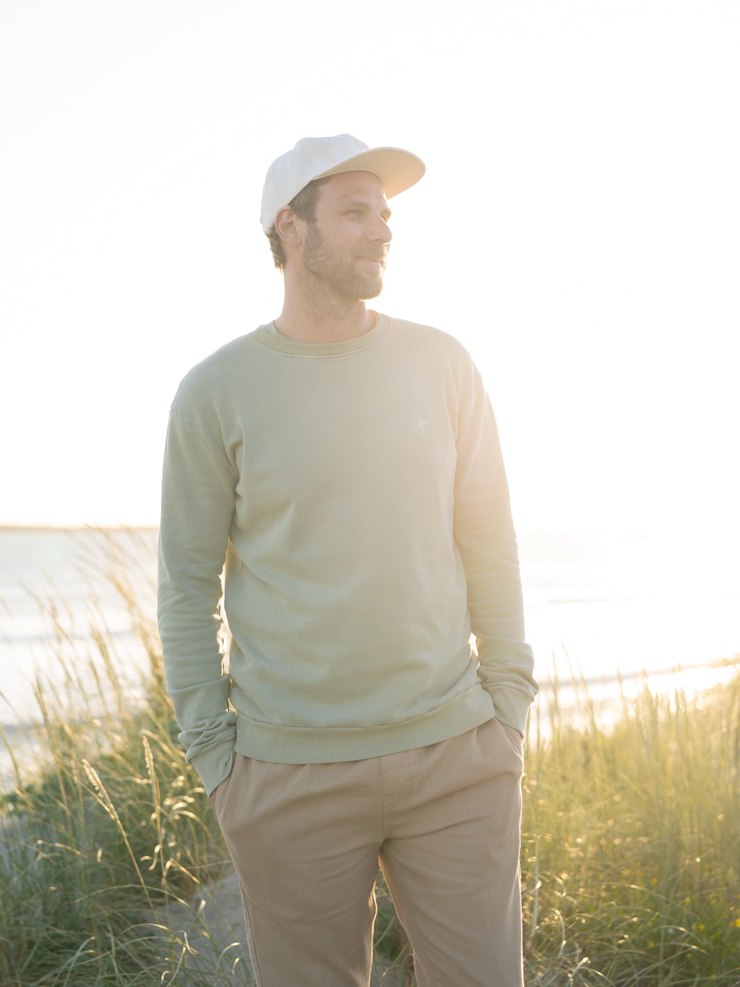 Männer Sweatshirt seegrün aus Biobaumwolle am Strand bei Sonnenuntergang