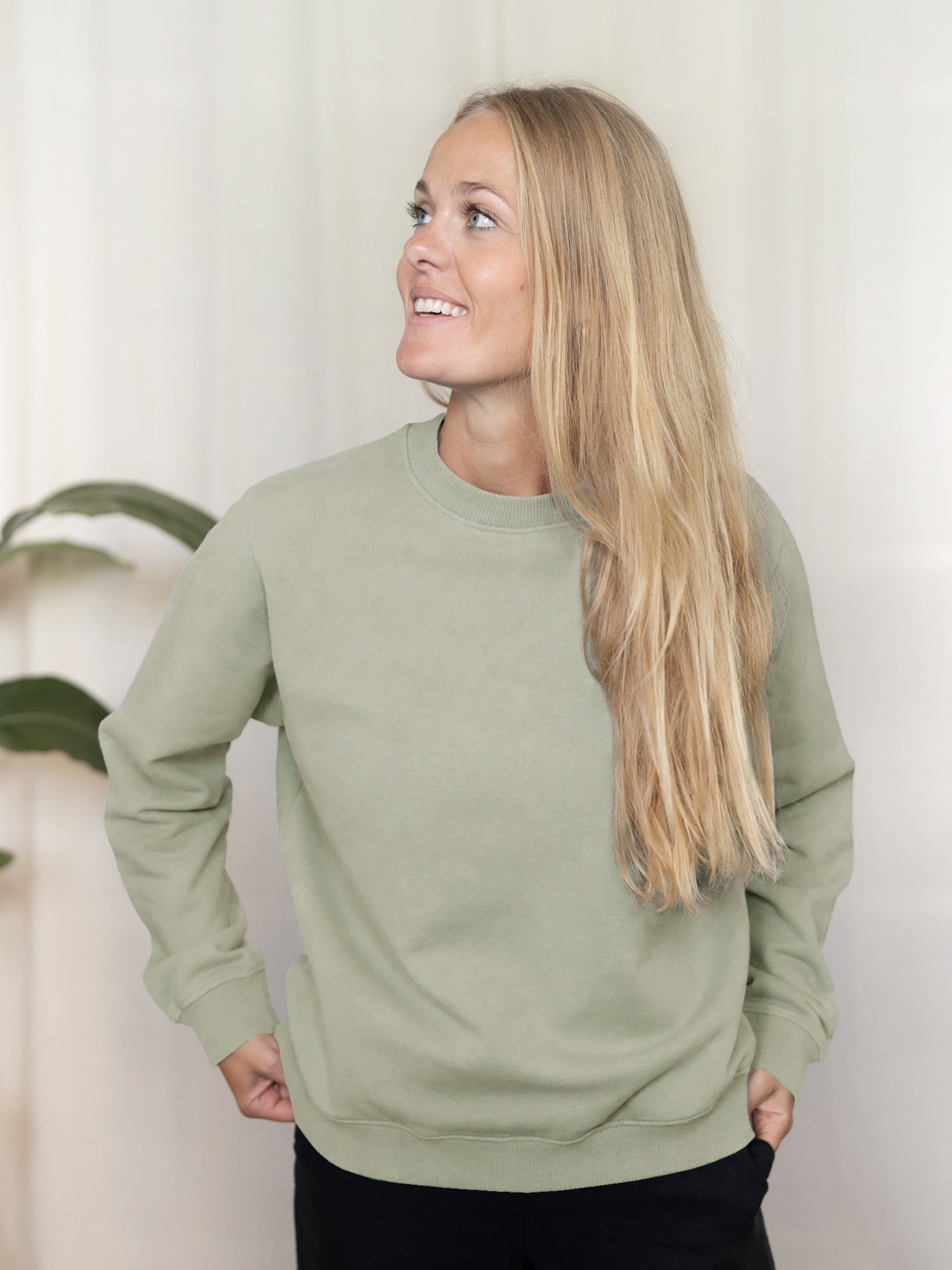 Nachhaltiges Frauen Sweatshirt seegrün aus Biobaumwolle und fair in portugal hergestellt, getragen von einer jungen blonden Frau